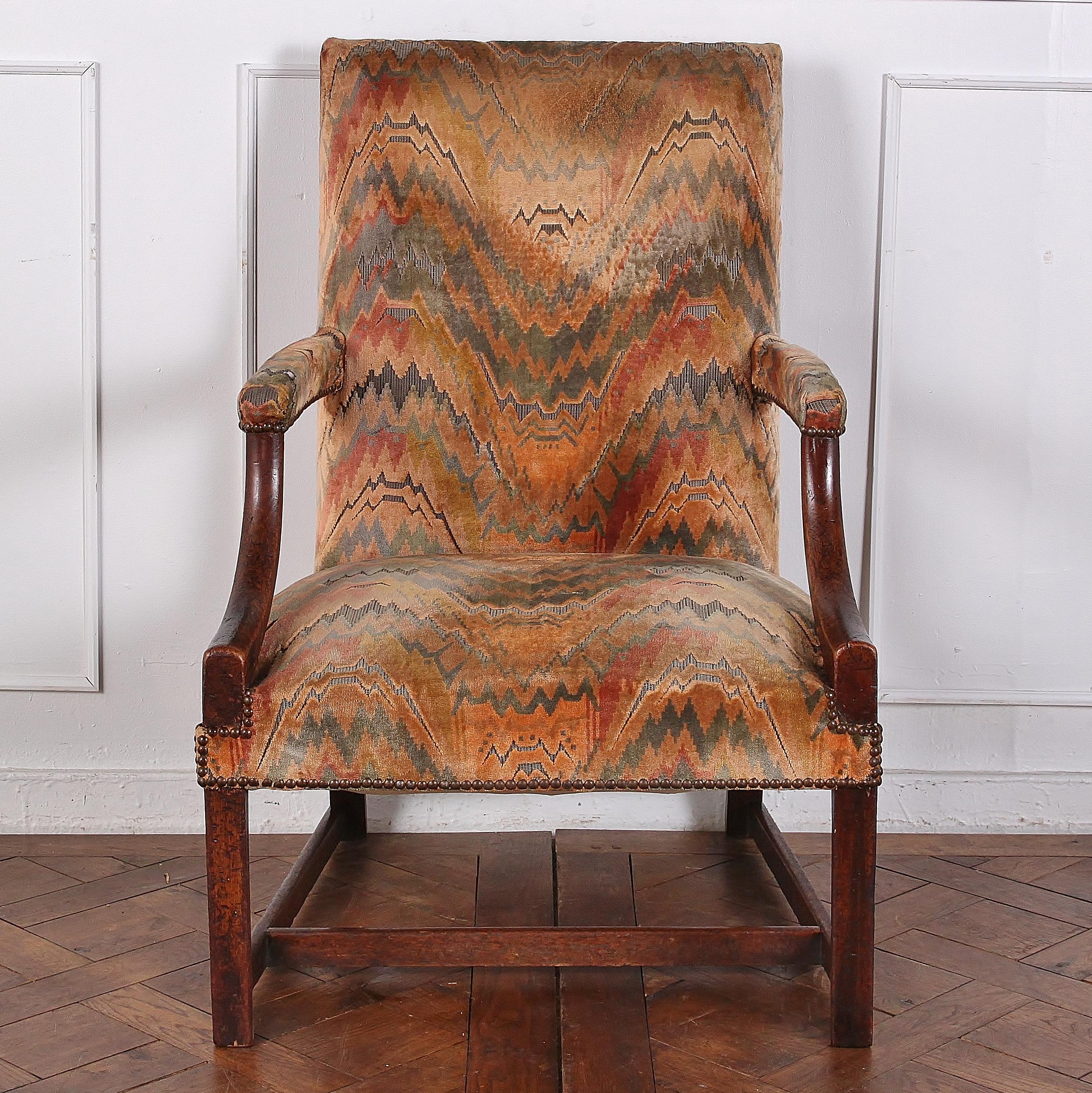 An English Georgian mahogany-framed open armchair or ‘Gainsborough’ chair of simple form.