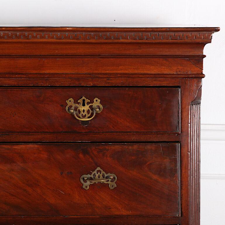 A late 18th century English mahogany Georgian five-drawer chest with two short over three long drawers, the case with canted fluted corners and a dentil-molded top. Later barley twist stand with curved stretcher and turned bun feet, circa early 20th