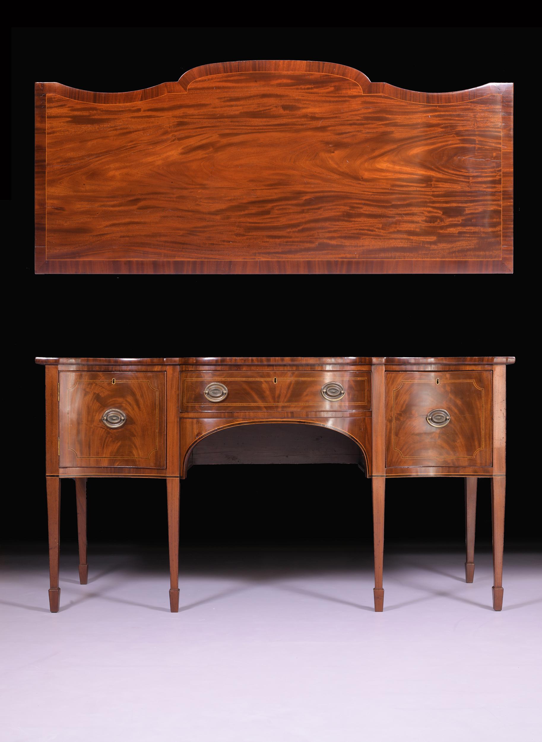 A fine and elegant Georgian period Hepplewhite serpentine shaped sideboard. Having a beautiful figured top over three drawers, raised on square moulded legs.

Circa 1780

English