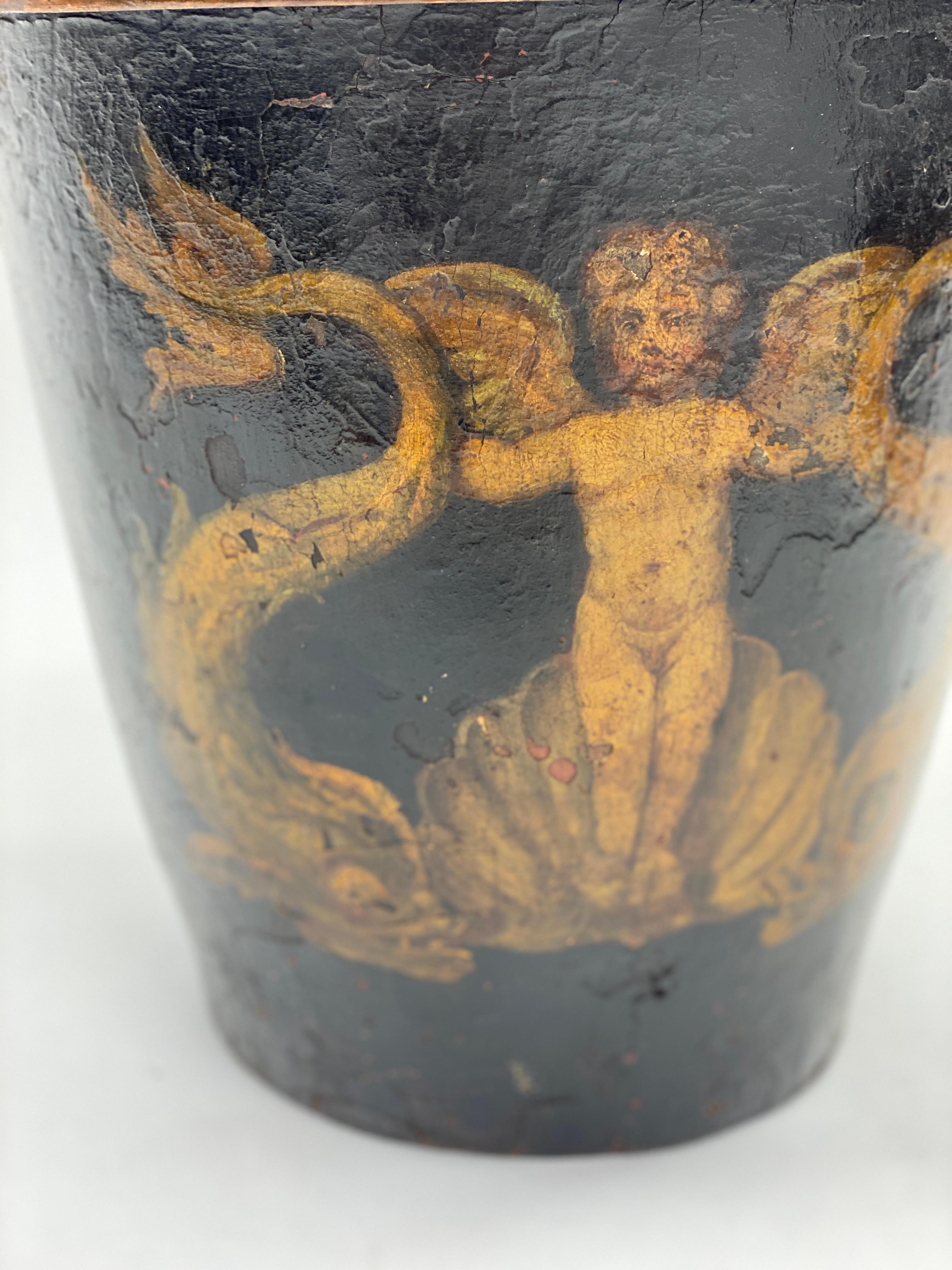 18th century English hand painted leather gallon fire bucket
Wonderfully aged and patinated oil painting of a cherub rising from a shell form flanked by dolphins. 
Copper banding on the top edge. 

18th Century England.