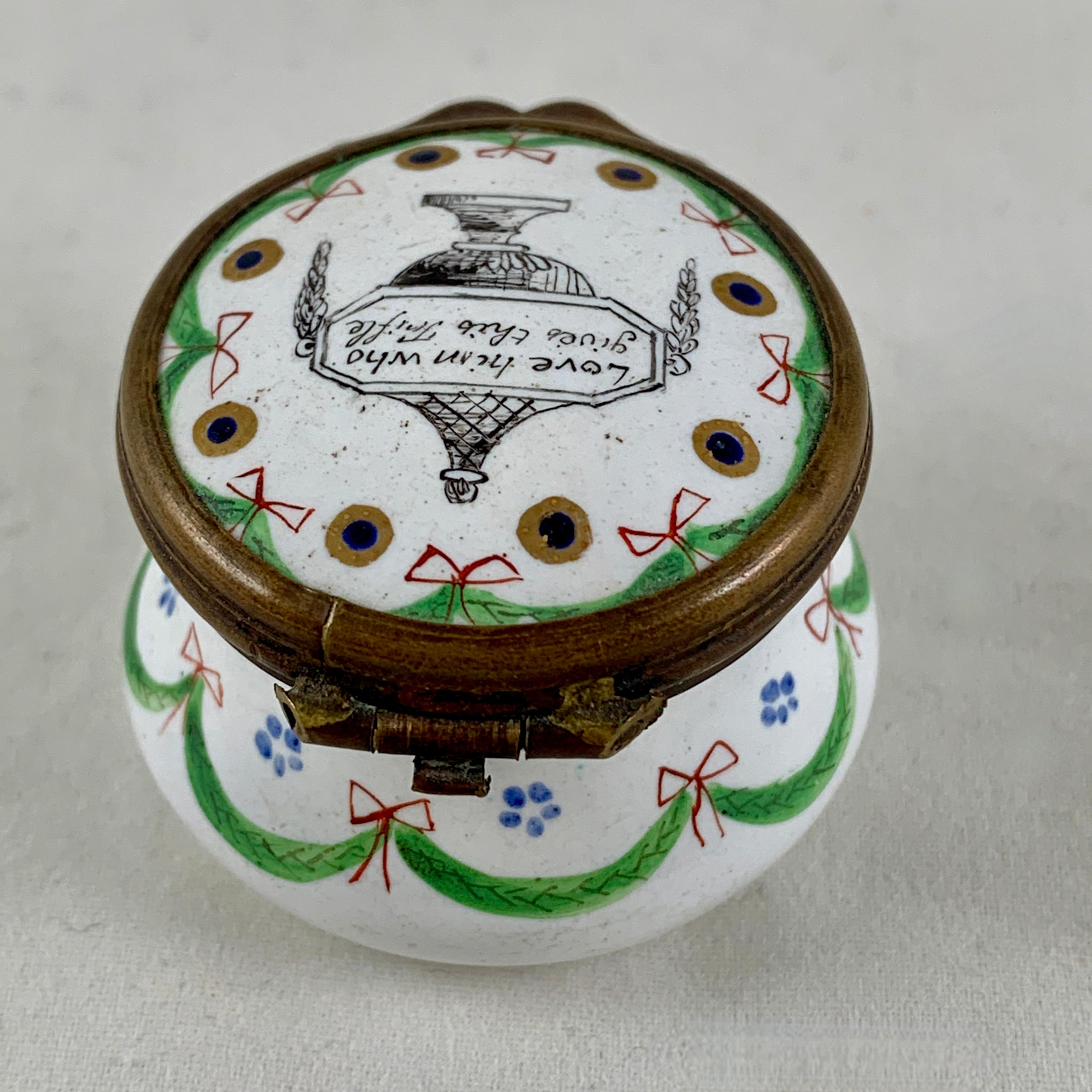 A late 18th Century English Bilston Battersea snuff or patch box, the motto reads, Love Him Who Gives This Trifle, hand lettered within the image of a footed urn. 

This box is also hand enameled with charming bows and swags, the sought after hour