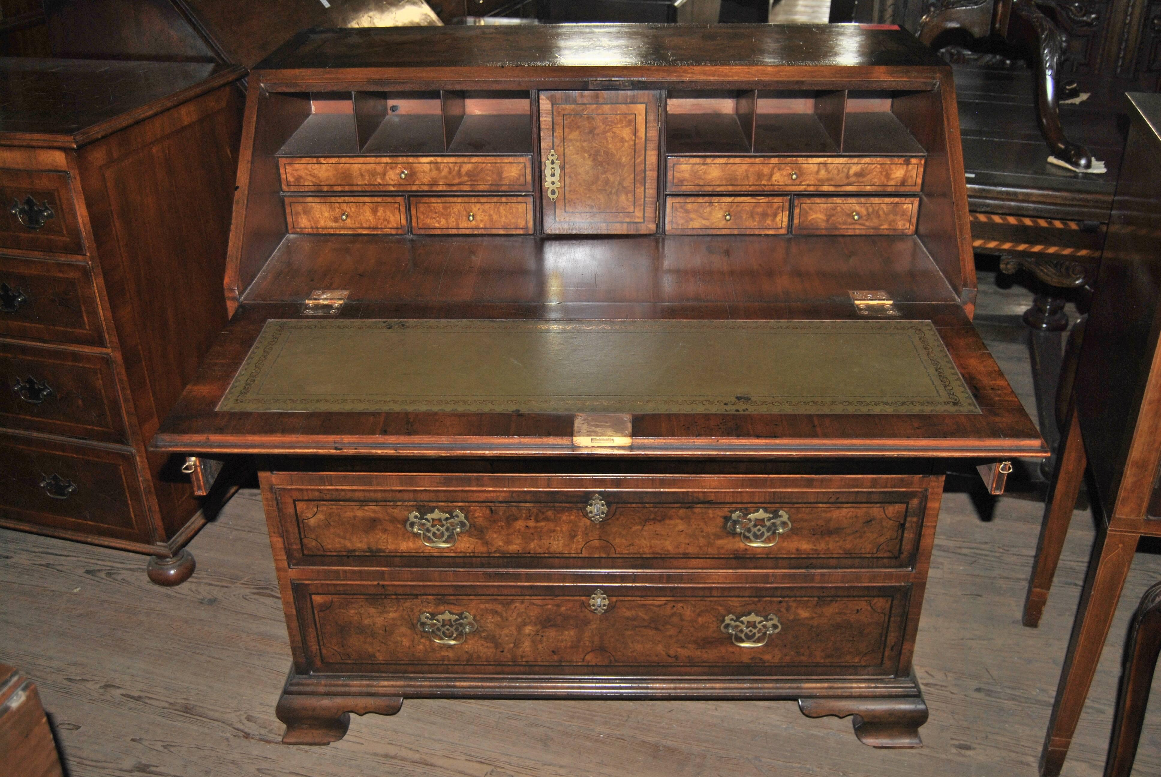 This is a slant front secretary or bureau made in England circa 1780. It is made of Kashmir walnut (the finest cut of burr walnut) and walnut. The top, the slant fall and the drawer fronts are all banded in walnut with a string inlay of ebony, with