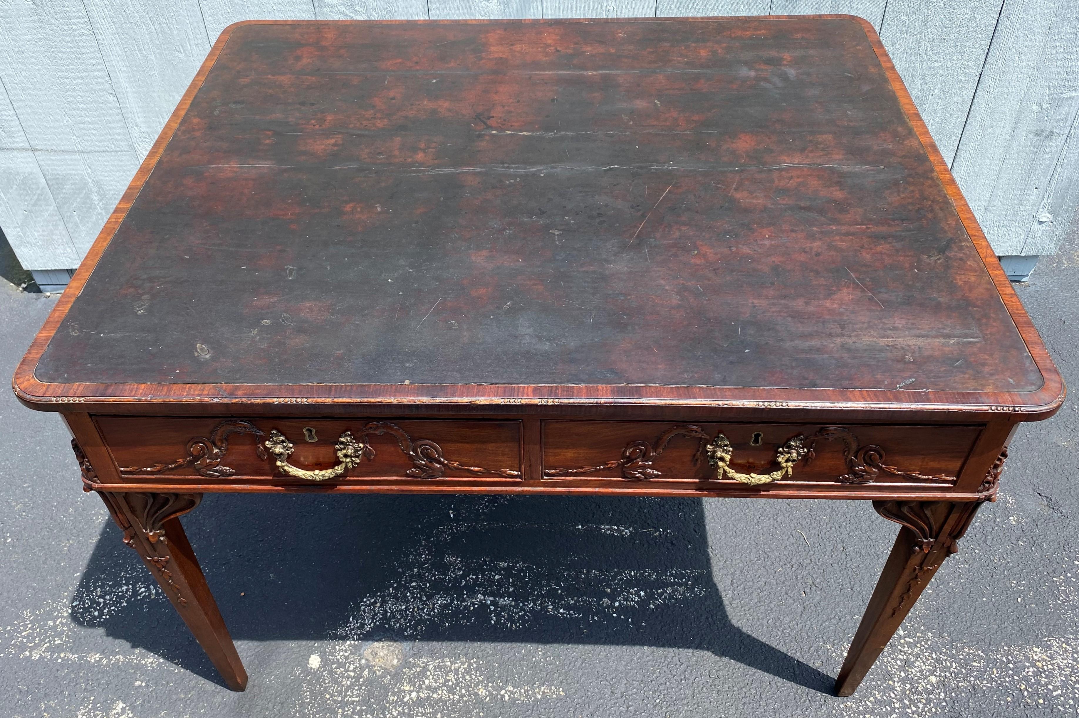 A fine proportion mahogany rectangular partners desk with brown leather top with a crossbanded border with delicate carving, surmounting a frieze with two fitted and cockbeaded document drawers on the front and back, each decorated with brass