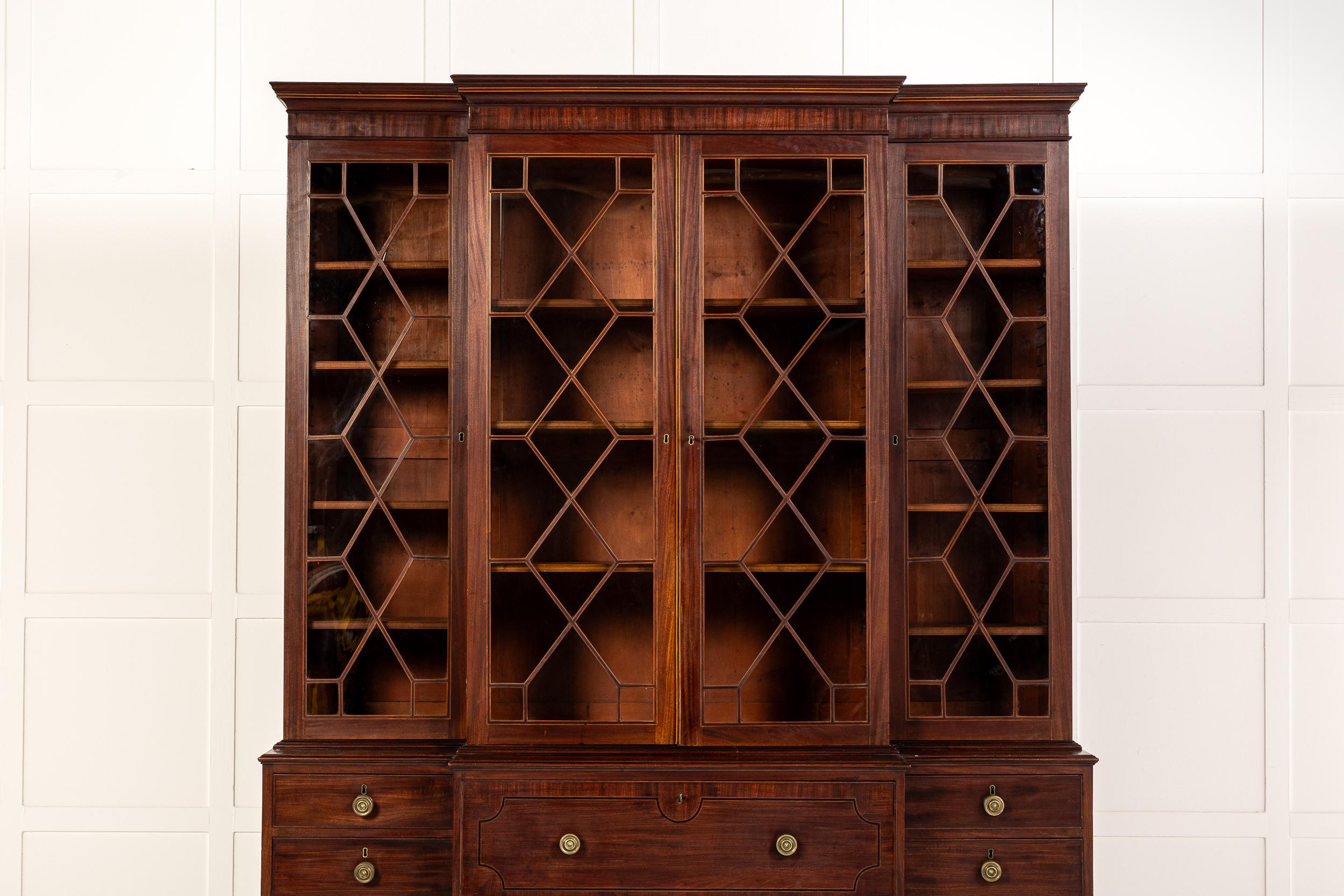 An Excellent Late 18th Century English Mahogany Breakfront Secretaire Bookcase.

This bookcase has a breakfront outline and is small in size.
The overhanging and moulded cornice above a plain frieze sits on top. Beneath this are four glazed doors,