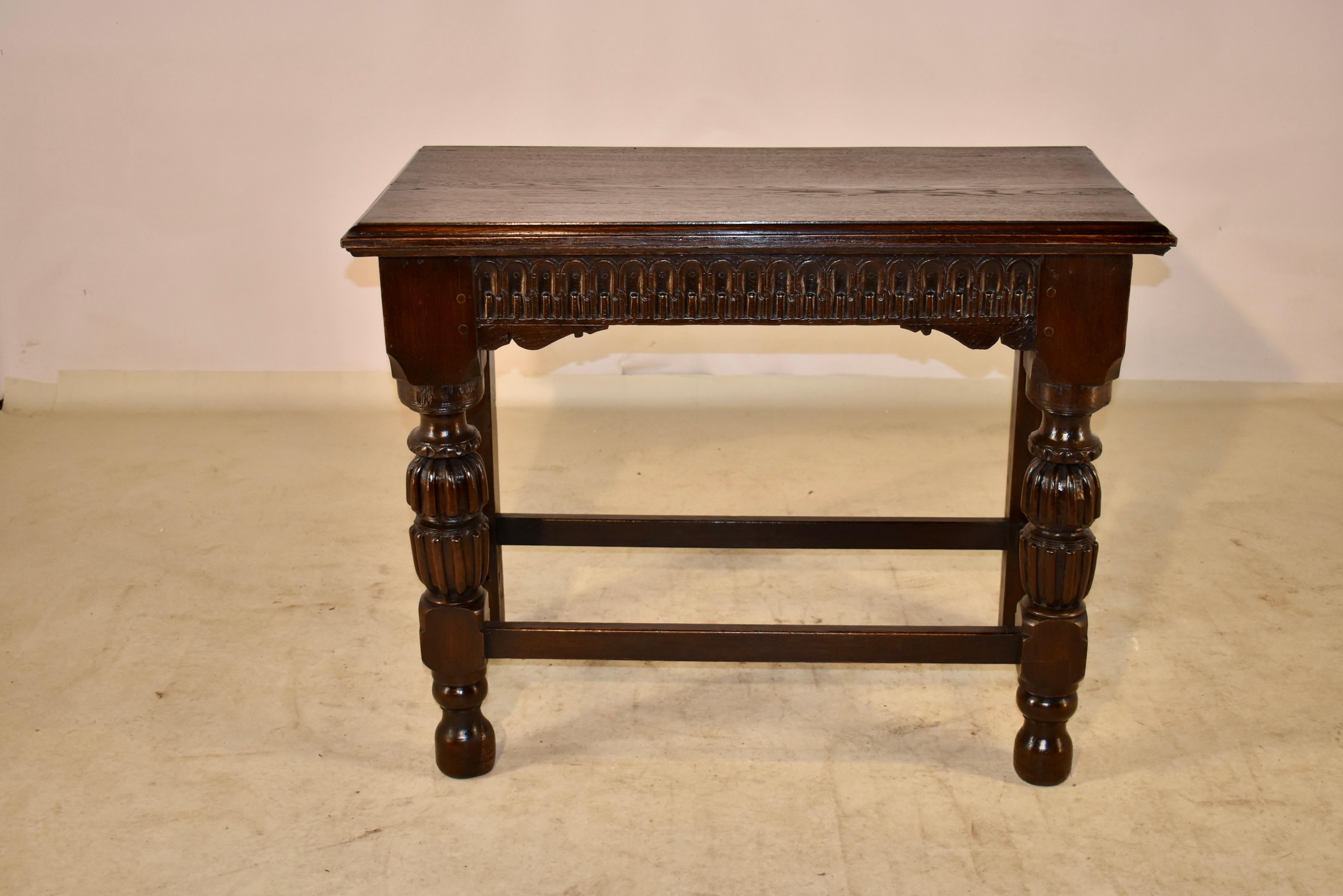 18th century oak console table from England. The top has a beveled edge, following down to a hand carved apron with nulling decoration over hand scalloped lower edges. The table is constructed with hand pegged detail, and is supported on hand turned