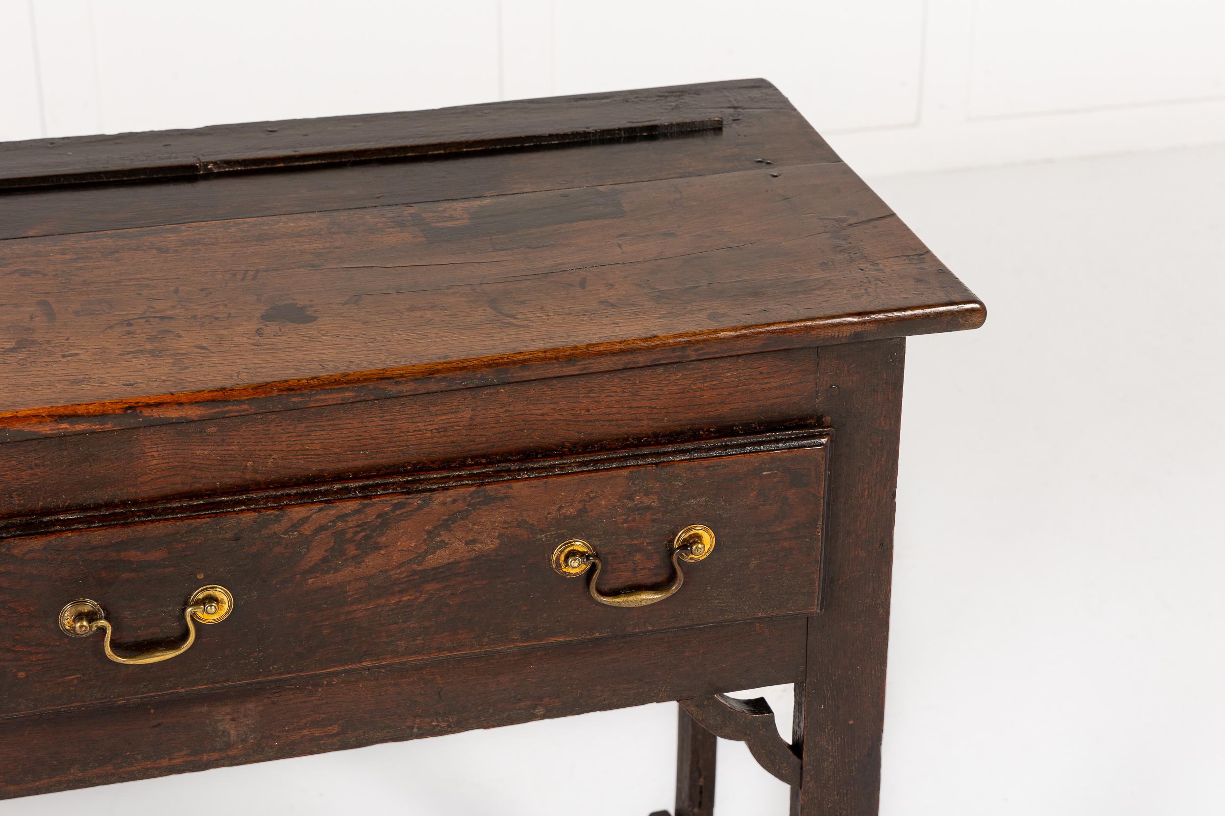 Un'eccentrica base per comò in Oak inglese della metà del XVIII secolo, di piccole dimensioni.

Questo delizioso pezzo presenta tutte le stranezze e gli elementi rustici associati ai più interessanti mobili di campagna di questo periodo. Il piano a