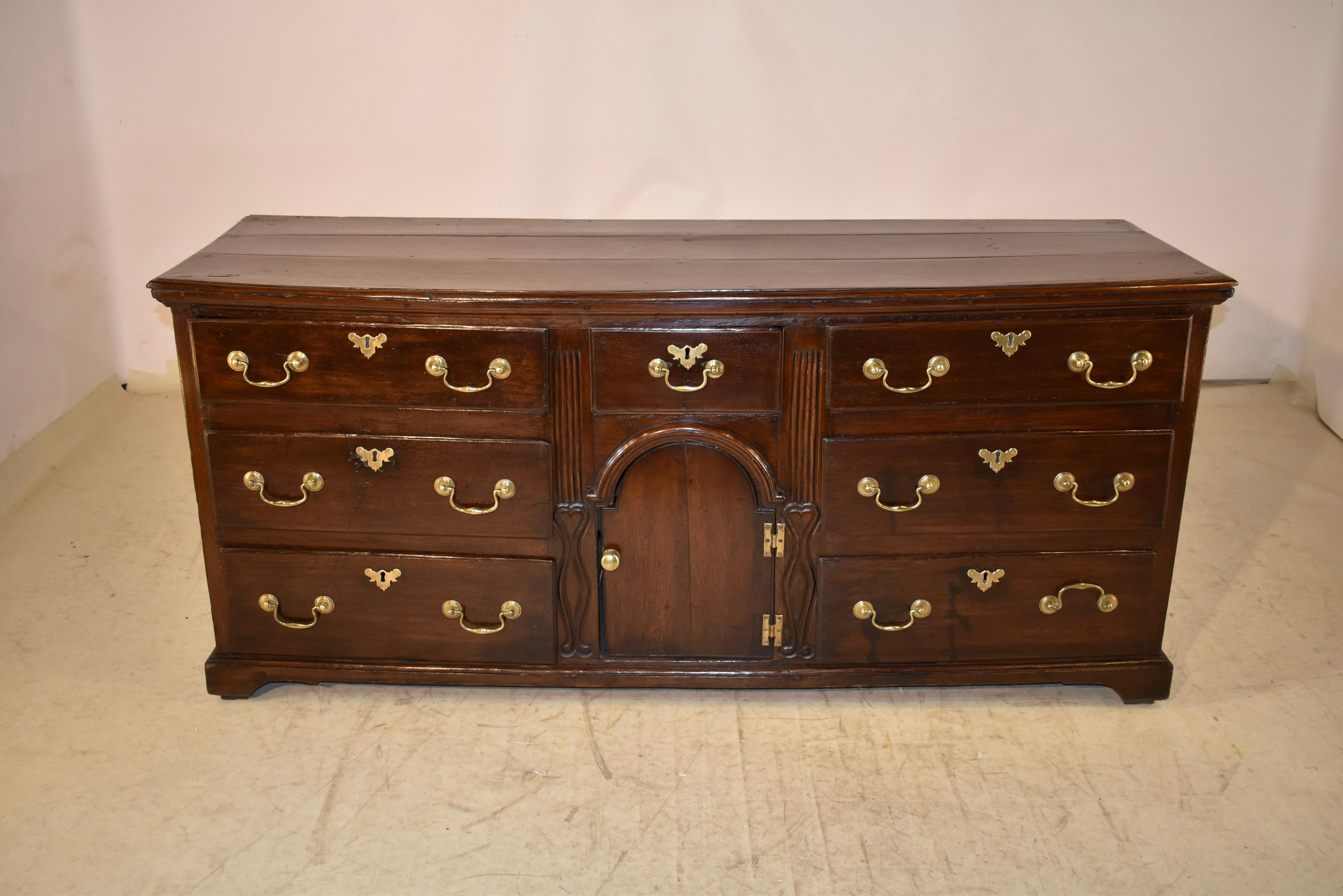 Mid- 18th century oak dresser base from England.  The top is made from  three planks and has a beveled edge. the sides have three panels, also with beveled edges for a simple and elegant feel.  The case is comprised of two banks of three drawers
