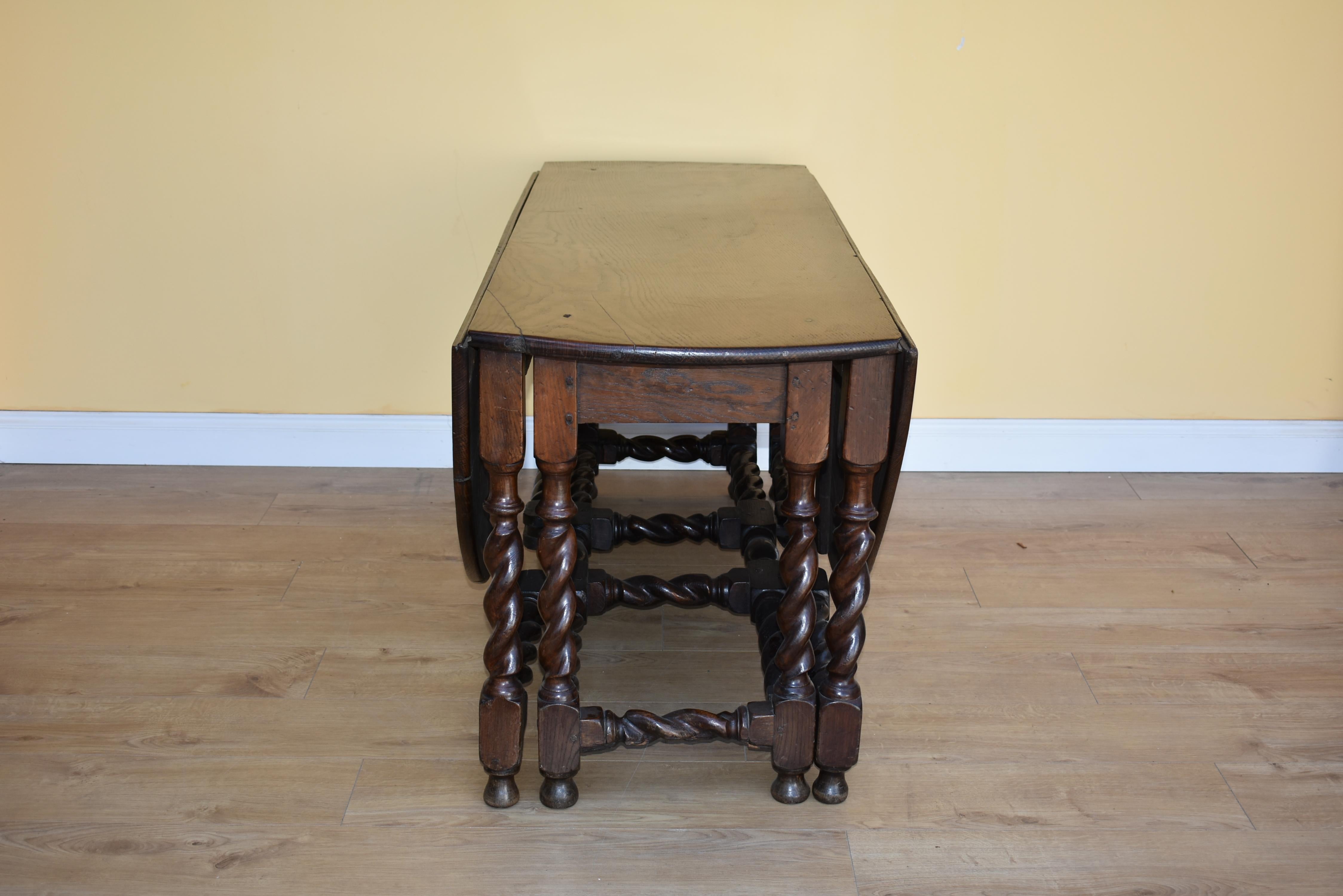 For sale is a good quality early 19th century double gateleg table. The solid oak top above nicely turned barley twist legs, the two flaps supported by a double gate when open. There are historical signs of shrinkage, though these were repaired