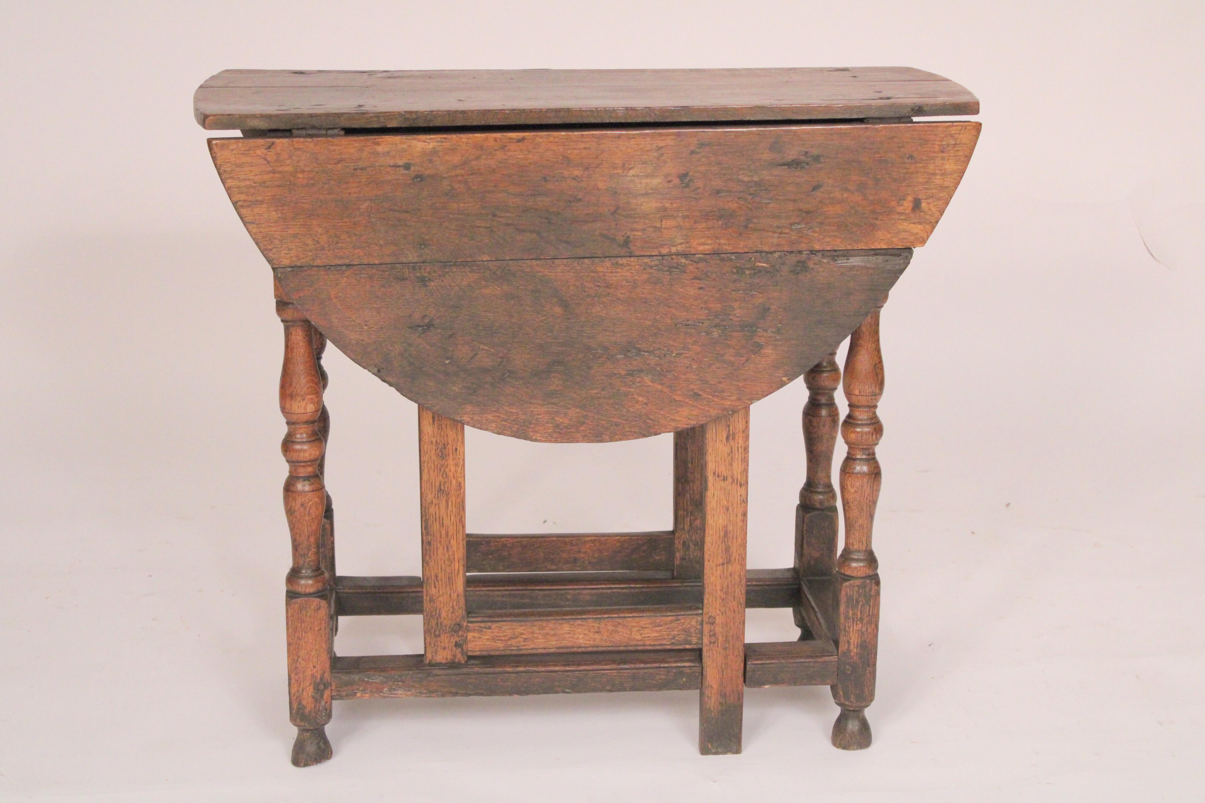 William and Mary style oak gateleg table, 18th century. With two D shaped quarter sawn oak drop leaves and a quarter sawn oak top, one frieze drawer, turned legs with stretcher bars resting on turned feet. Dimensions of top when drop leaves are