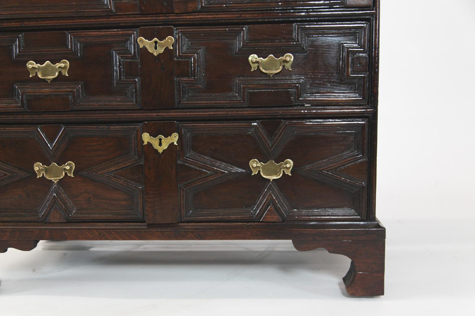 18th century English oak geometric chest, with two over three drawer arrangement with varying geometric designs on bracket feet.