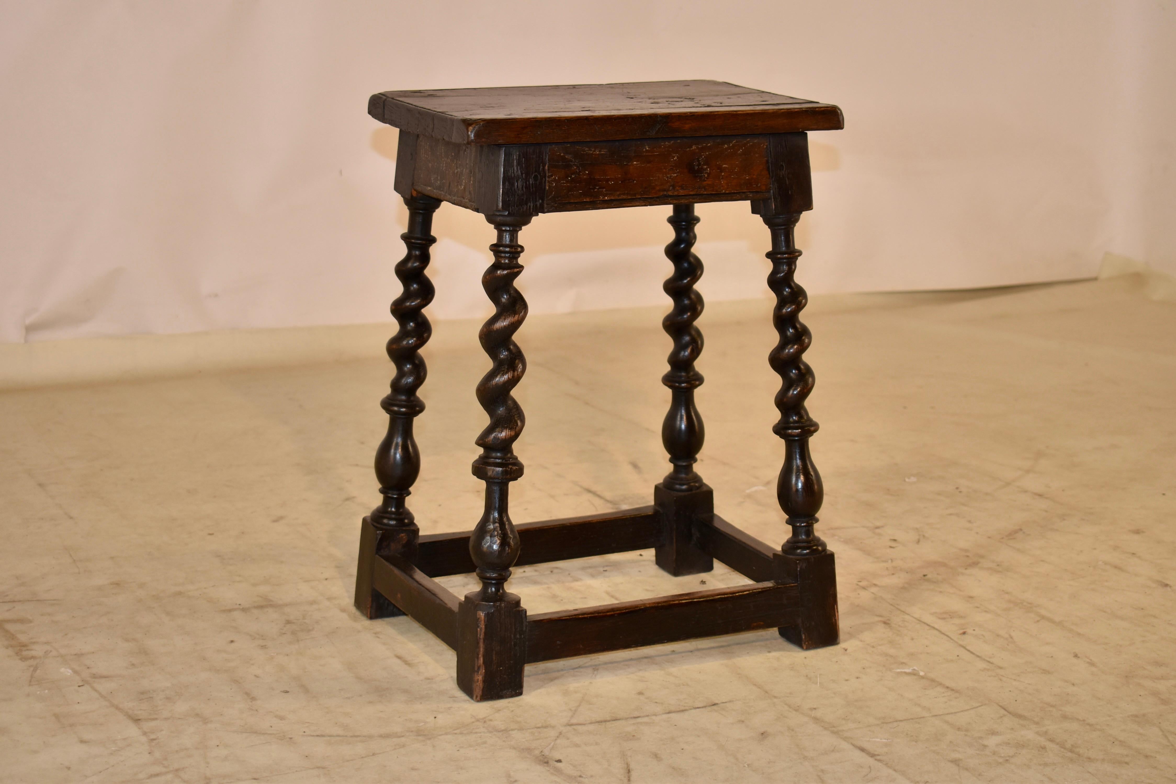 18th century oak joint stool from England. The stool is made from pegged construction and has a figured elm seat, which has routed edges for added design interest. This follows down to a simple apron and fantastic legs. the legs are splayed and are