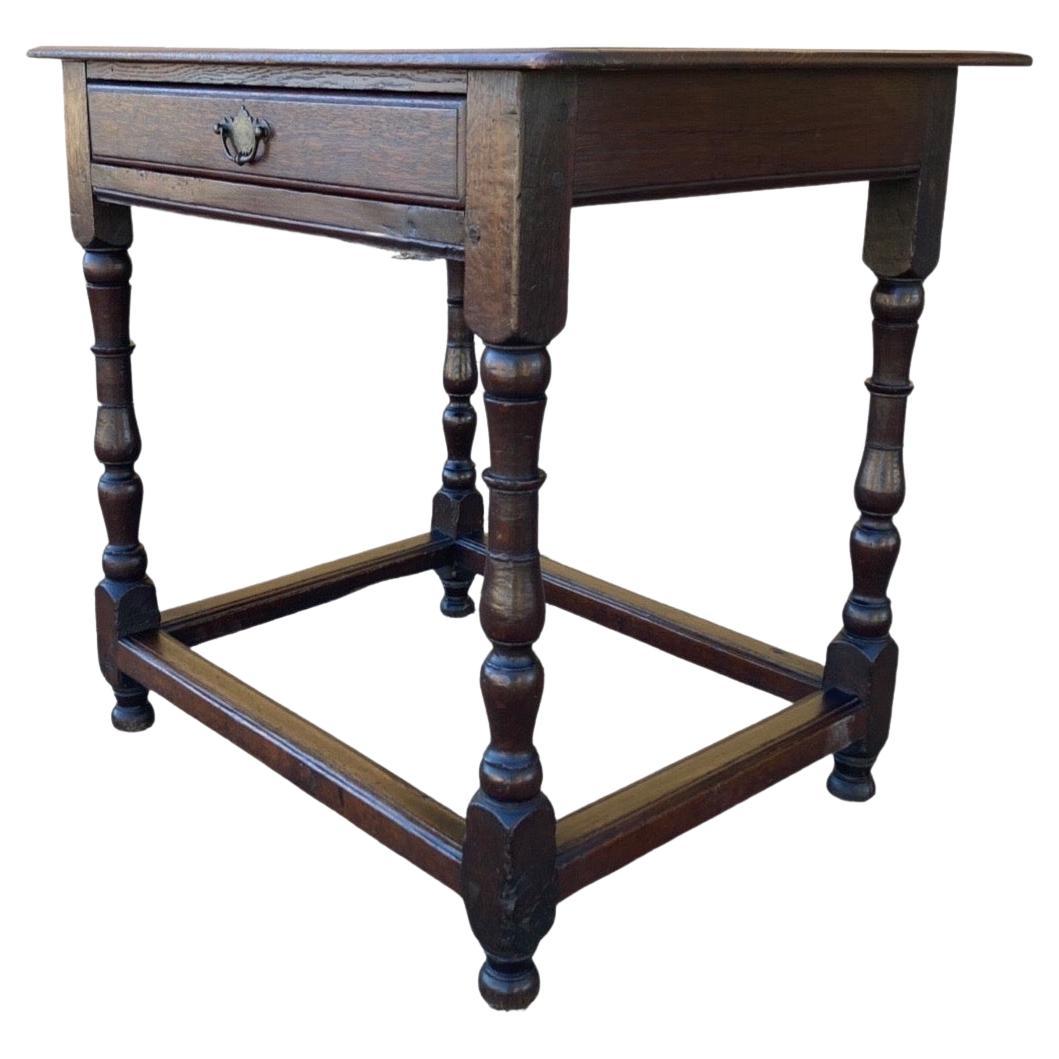 English side table made with oak in the late 1700s. This is a beautiful little table with elegant proportions and gorgeous finish. The side table features a rectangular top made using three boards with an ogee edge, nailed and pegged to a simple,