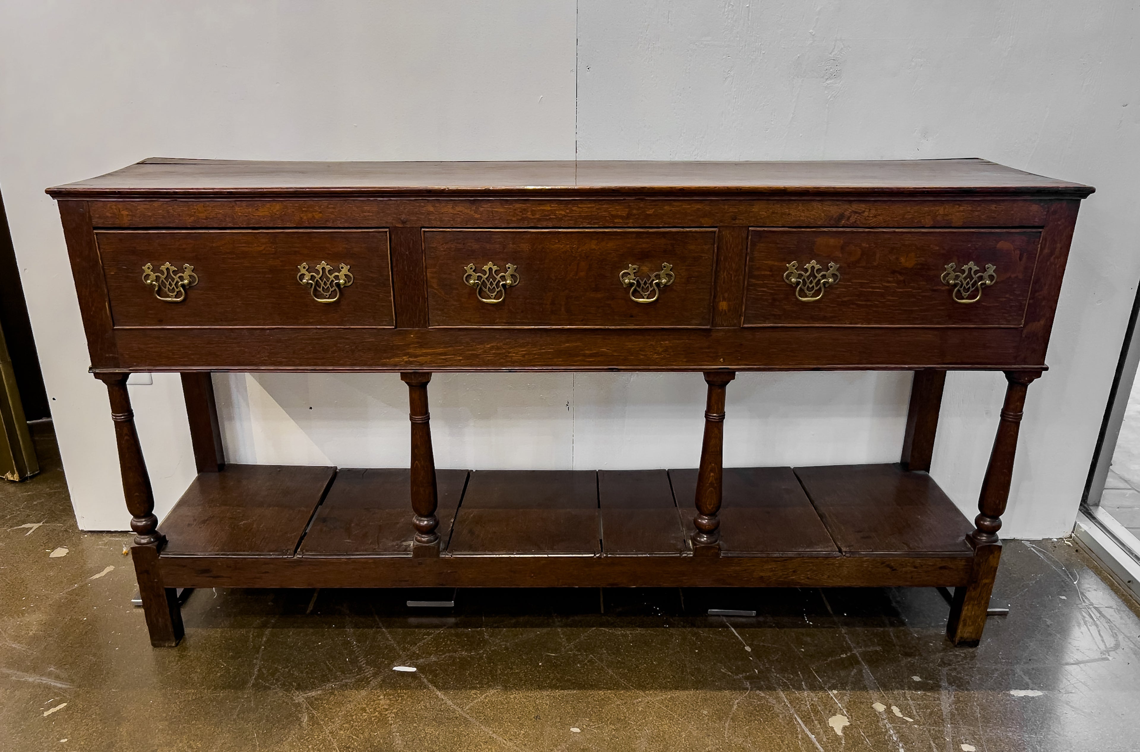 18th Century English Oak Sideboard with turned front legs and 3 drawers. This piece is made from peg construction, dovetailed drawers and the original hardware is in tact. The top of this piece initially had another piece on top of it, however it