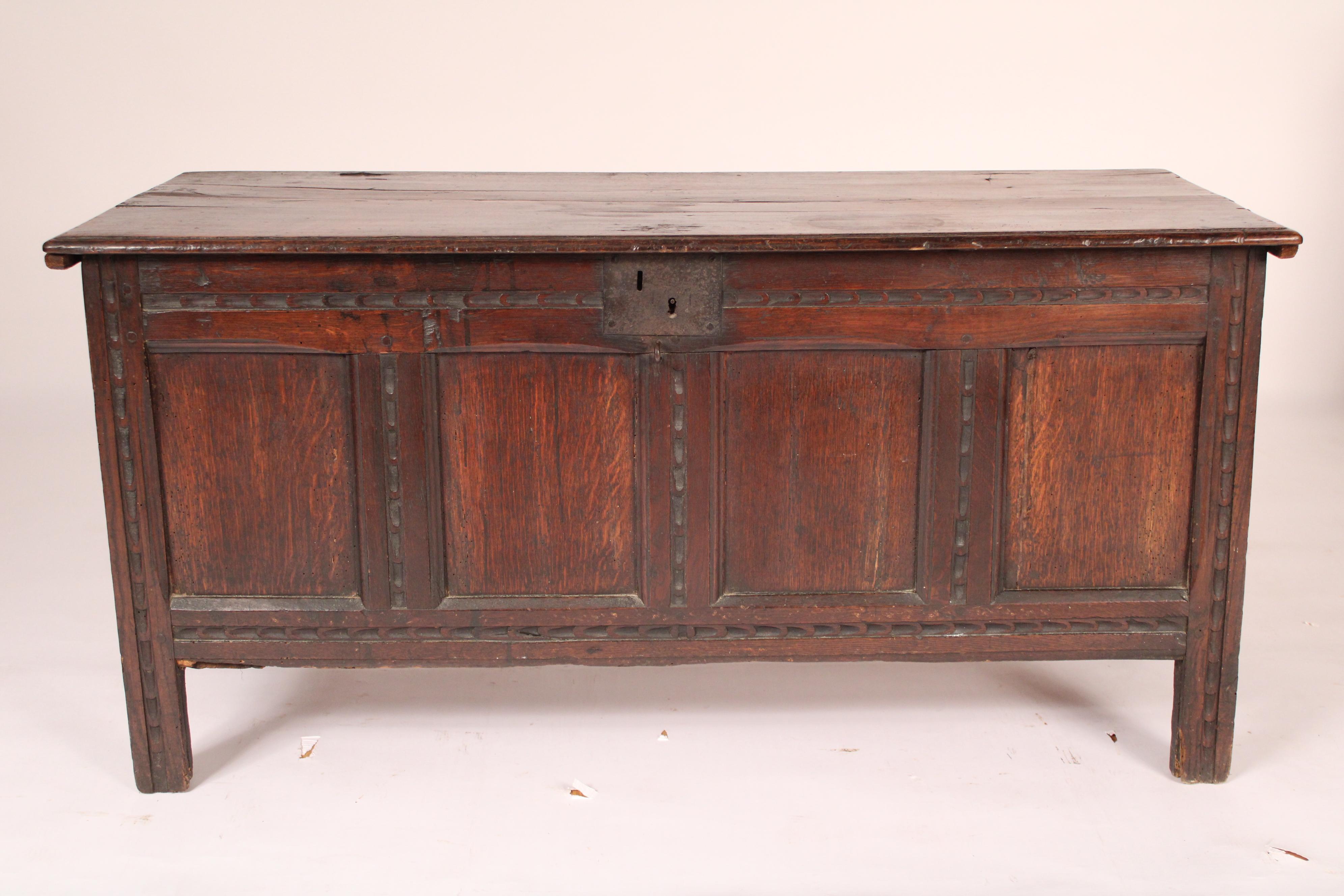 English oak trunk, 18th century. With a two board hinged oak top with molded front and side edges, 4 panel front resting on straight legs. Mortise tenon and peg cast construction. Nice old patina.