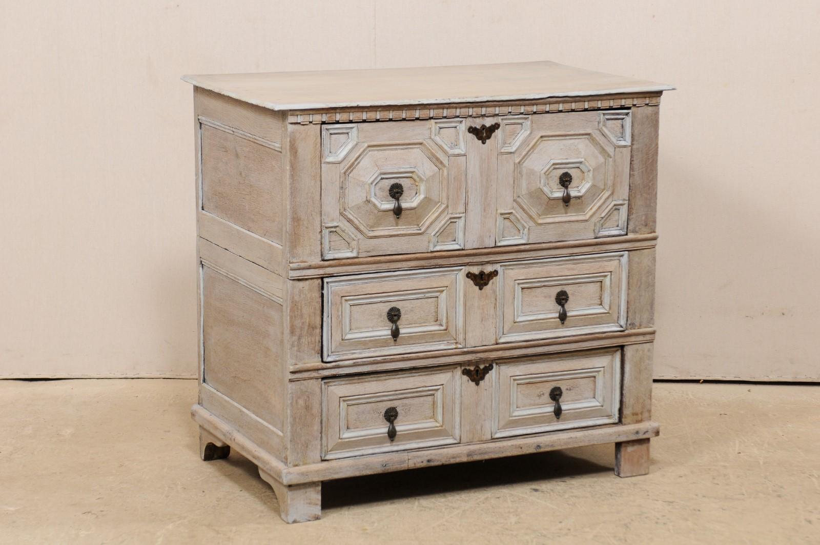 An English carved wood chest of three drawers from the 18th century. This antique chest from England has a rectangular-shaped top with beautiful accent trim just under the top front lip, and fabulously carved geometrical designed paneled fronts