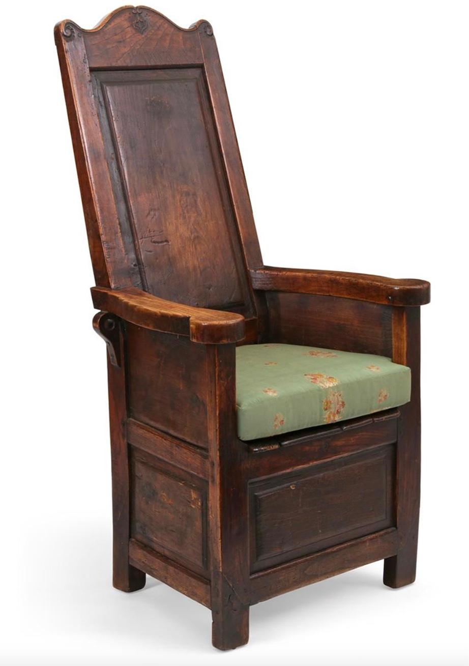 An English stained oak and elm paneled armchair, incorporating antique and later elements from the 18th Century.