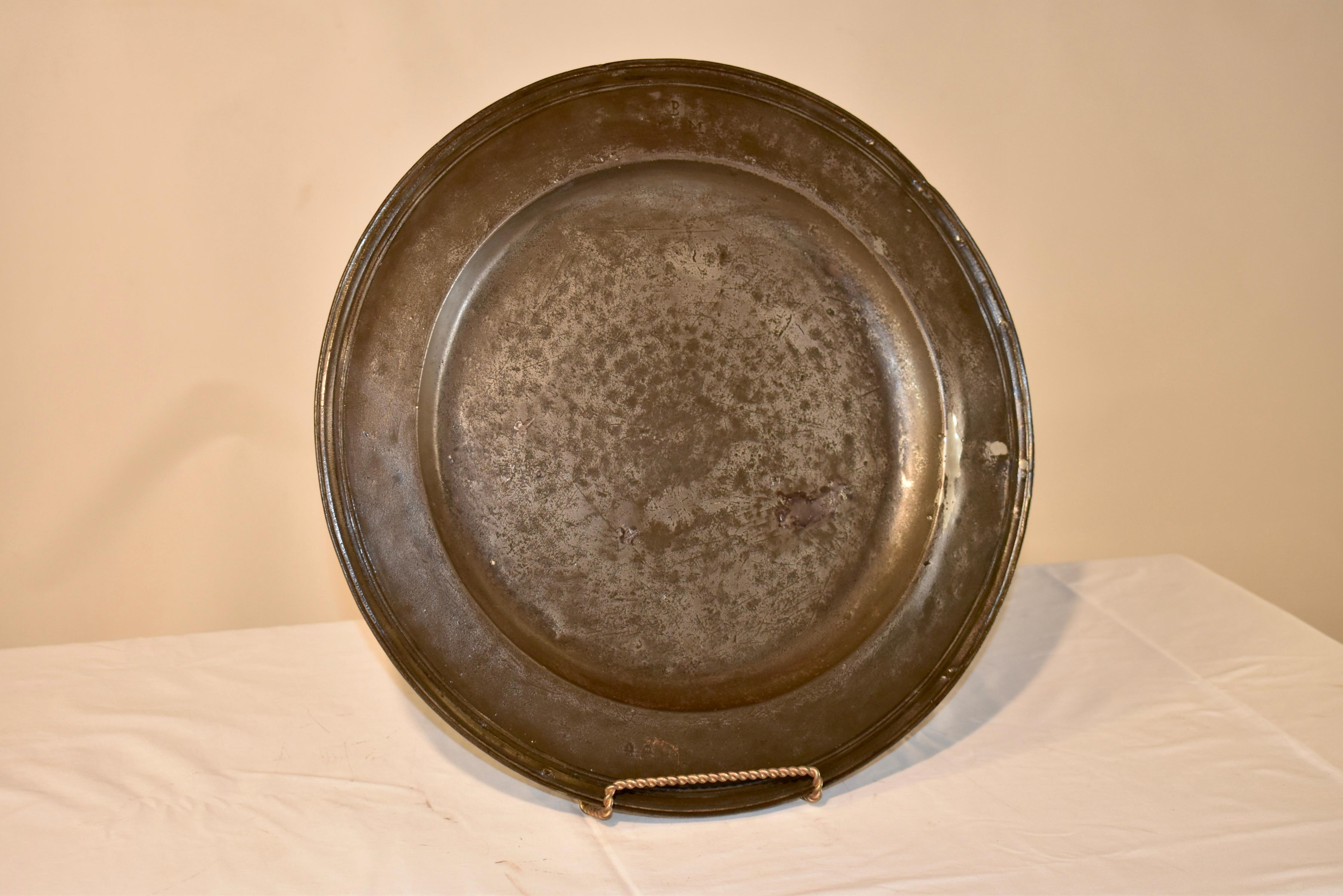 18th century large pewter charger with wide rim and molded edge, which is very elegant, especially for pewter, which was used more frequently for casual dining. there is a hallmark on the rim, which is photographed. Plate stand not included.