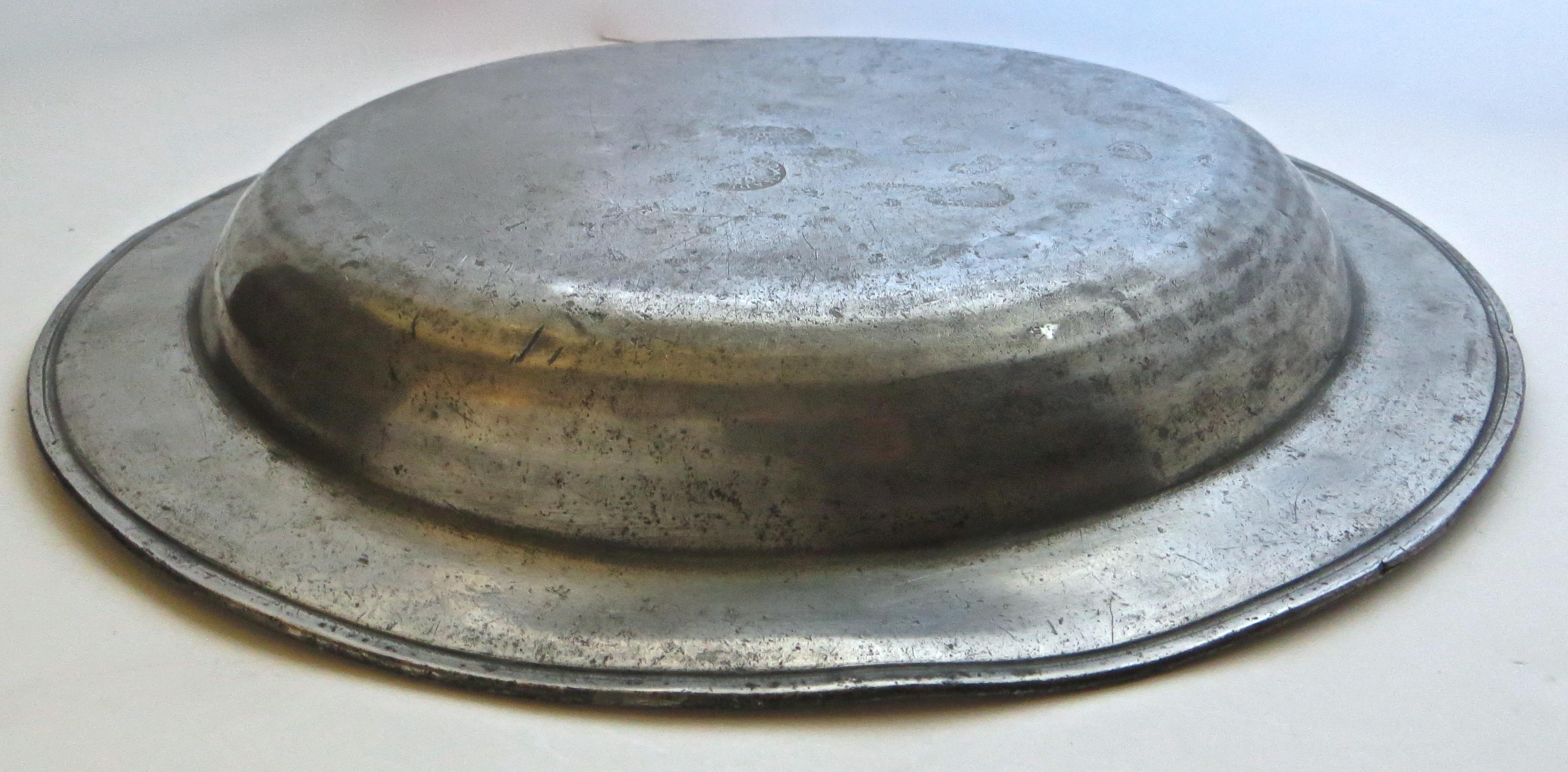All original early 18th century pewter dish, hallmarked on the rear of the gently rounded bouge; three touchmarks are visible albeit not completely discernible. The most visible states 