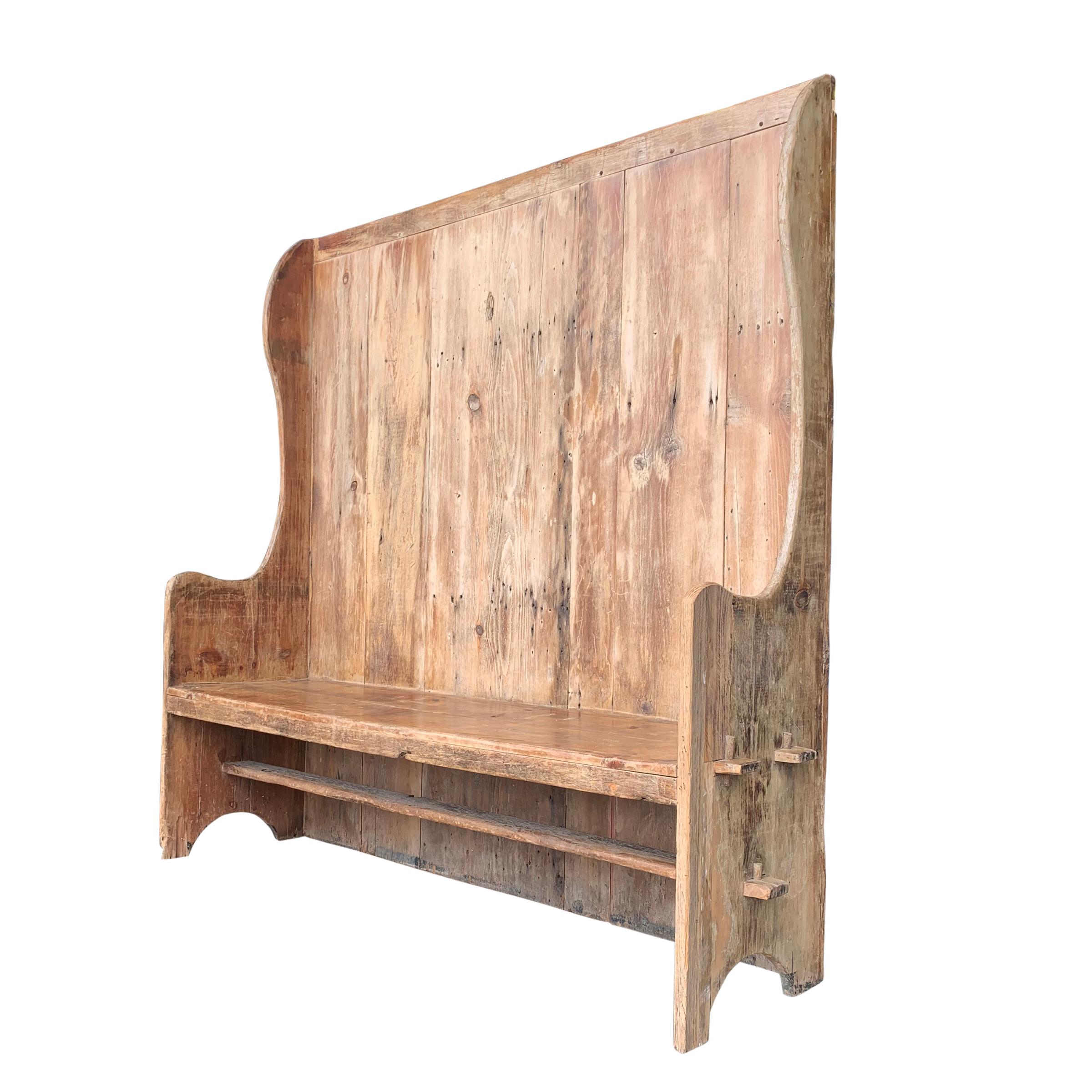 A wonderful 18th century English pine settle with a wide seat, a high back, wings, gently curved arms, and a wonderful natural patina. The seat is pegged into the sides, and is very sound!