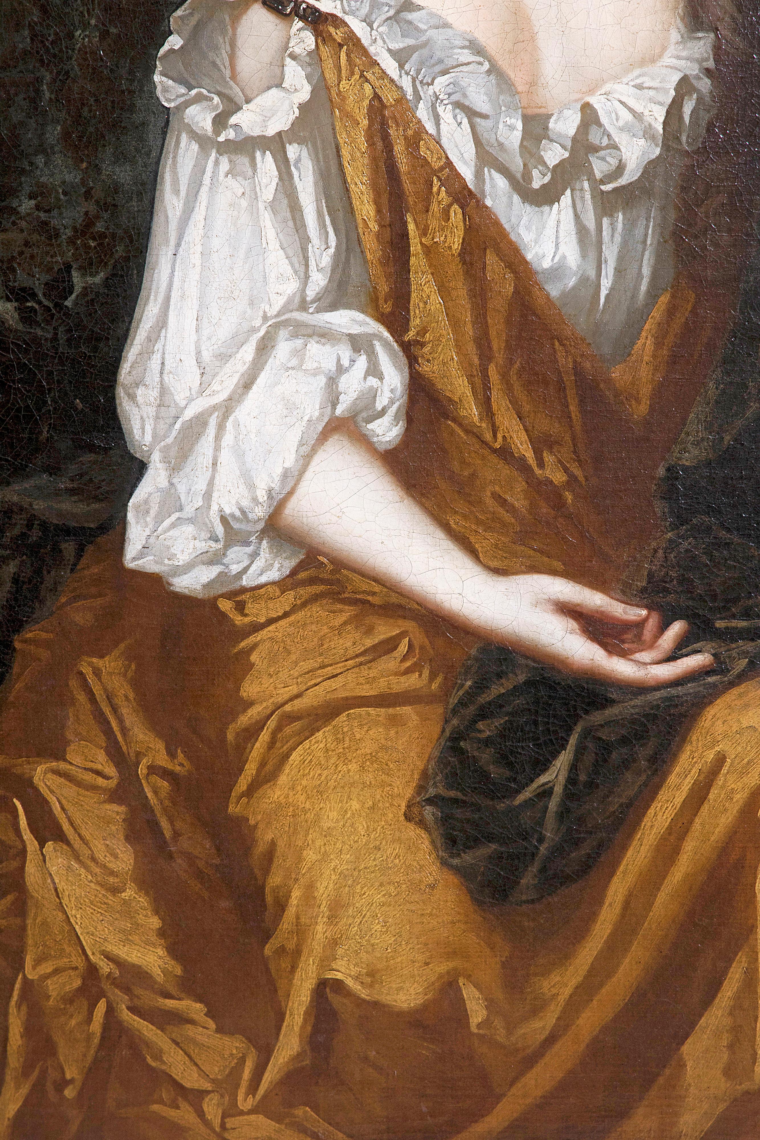 A well-executed large oil on canvas portrait of Mrs. Overbury seated three-quarter length, wearing a gold dress with a brown cloak, a landscape with a parkland beyond inscribed with the name of the sitter. The quality of the painting suggest an