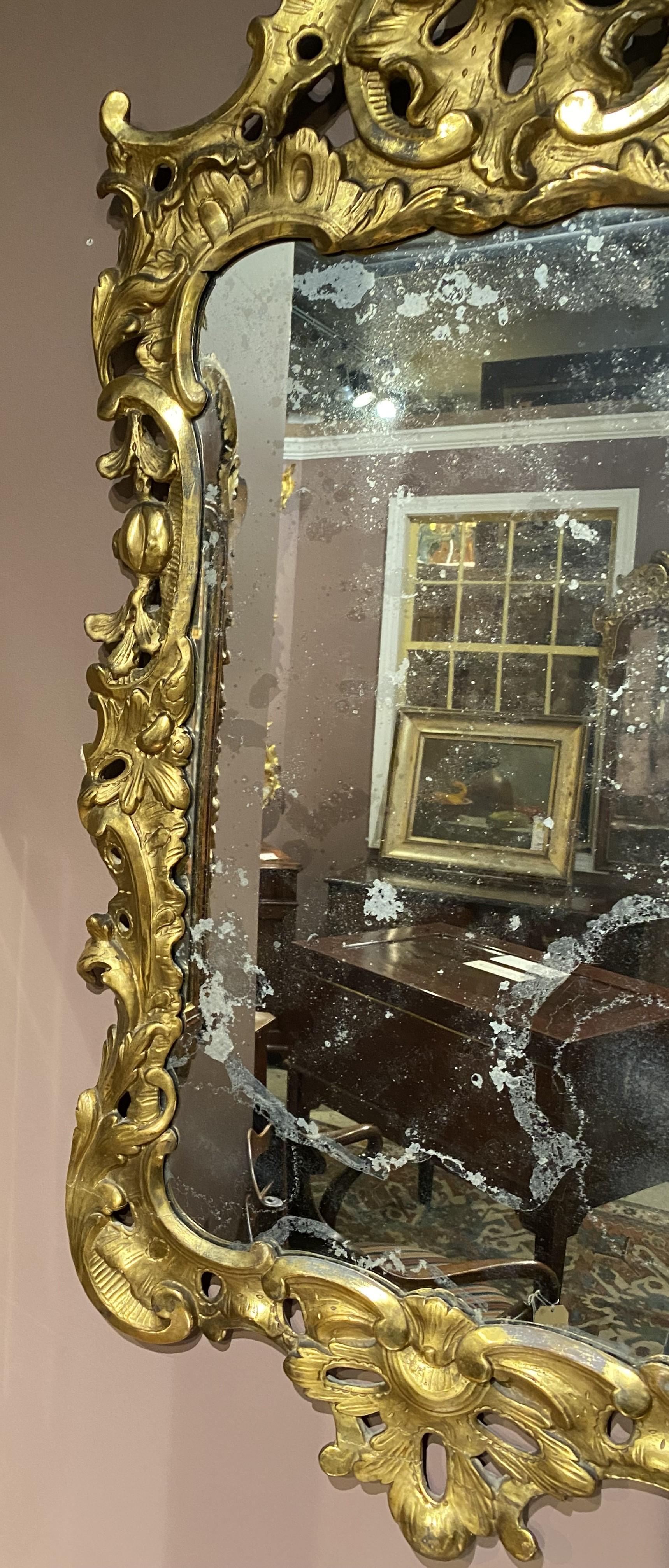 Sculpté à la main Miroir mural rocococo anglais du 18ème siècle avec cadre en bois doré sculpté en volutes en vente