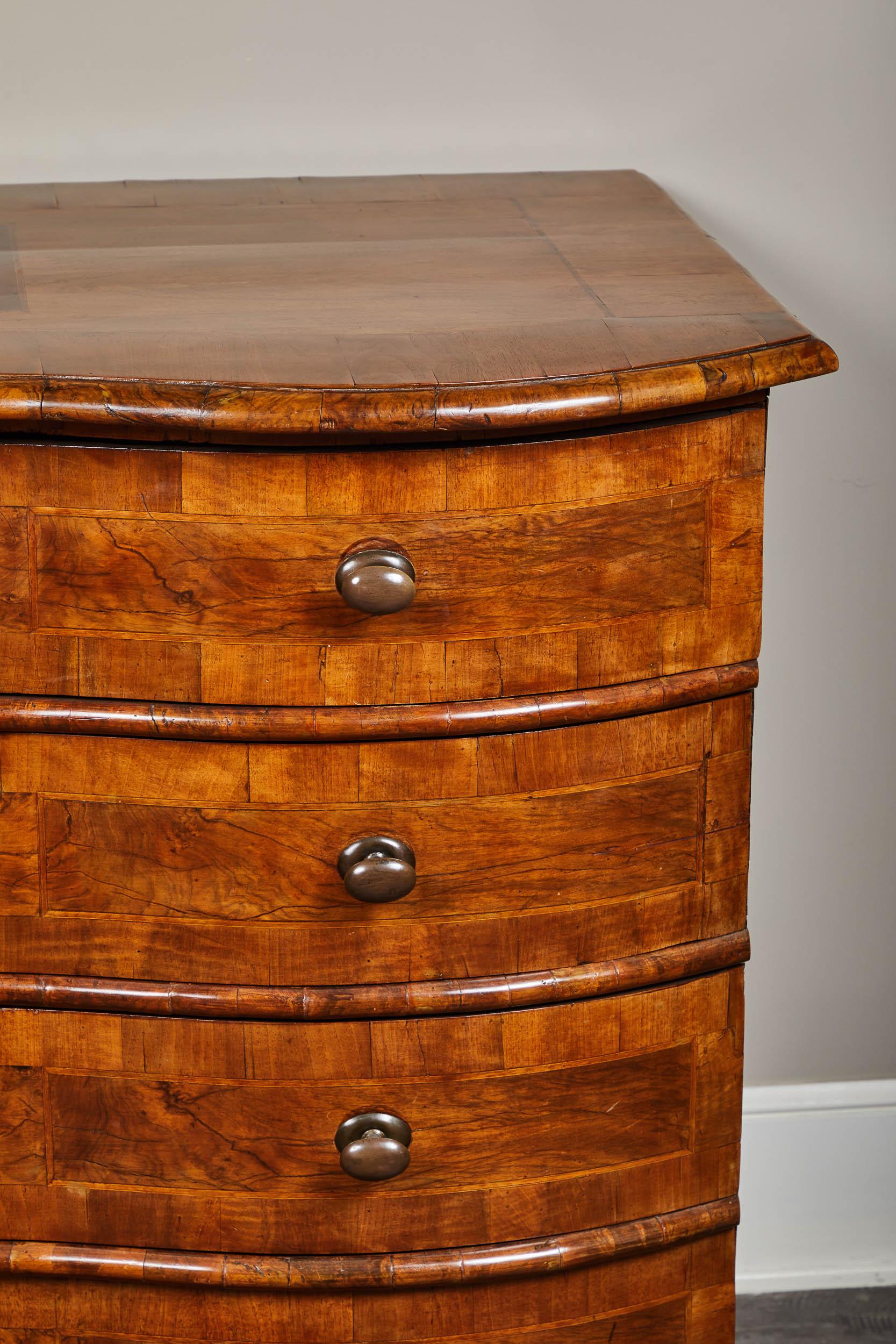 An 18th century English walnut four-drawer chest with a serpentine front. Features an inlaid top and a simple, timeless shape. Great as entry casepiece, or functional bedroom storage.