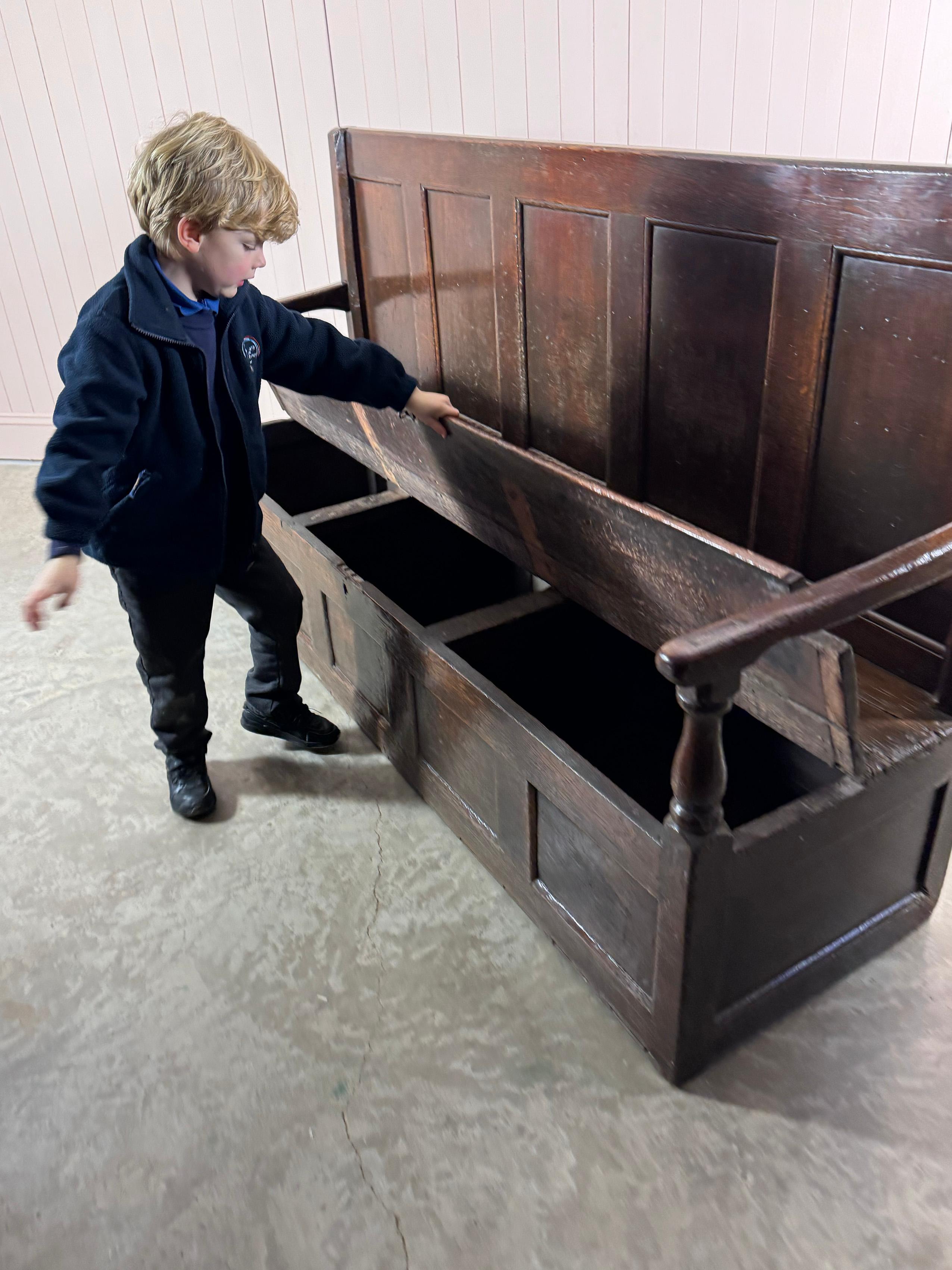 We sourced this handsome panelled oak settle from The Old House, Aspley Guise, Bedfordshire.

Early 18th Century with a leather hinged seat with storage underneath.  All in very good condition for its age and structurally sturdy with 200 years of