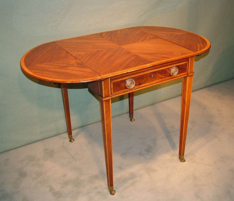 Une table Pembroke de la fin du 18ème siècle de la période Sheraton en acajou doré et figuré, avec des bandes croisées en bois de satin et du buis et de l'ébène partout, ayant un dessus inhabituel plaqué en quart de cercle et terminé en 