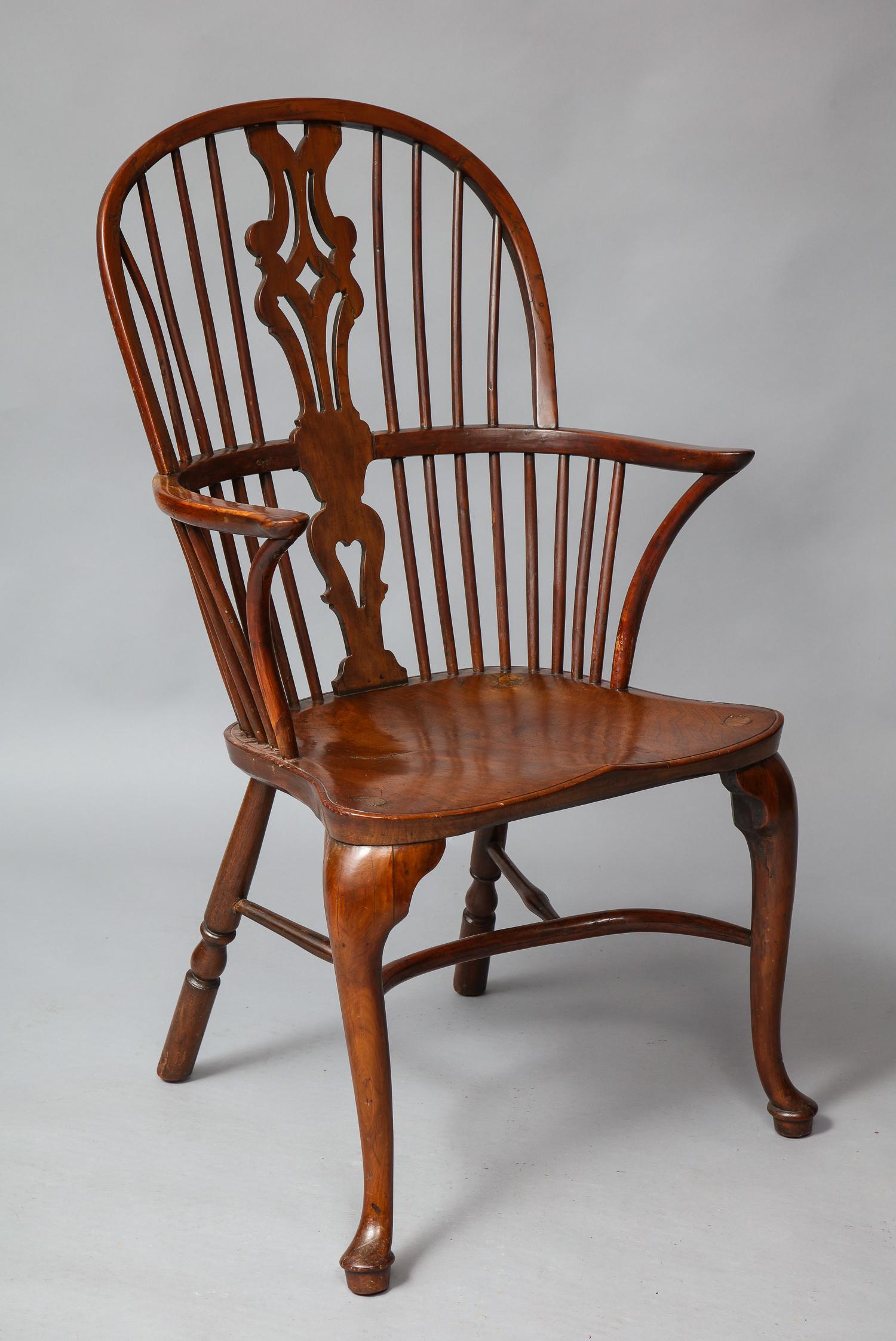 Very fine mid-18th century Thames Valley yew wood Windsor armchair, the hoop back with fret work splat, over crook supported continuous arm, the nicely saddled elm seat with vivid graining, standing on cabriole legs with padded feet, joined by