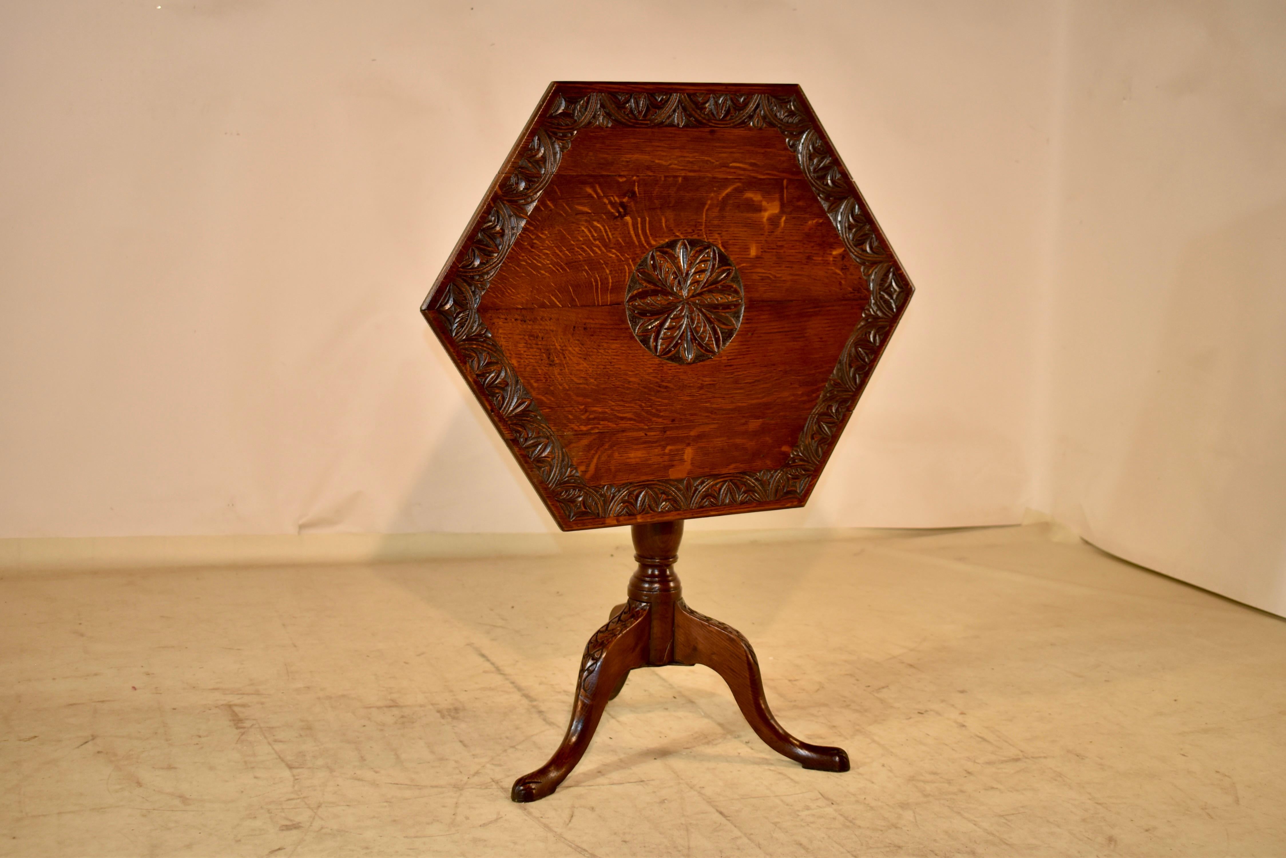 18th century Oak tilt top side table from England. The top has a central carved medallion, surrounded by a carved banded border. The top is hexagonal in shape and tilts for easy storage when having company, or just needing a little extra space when