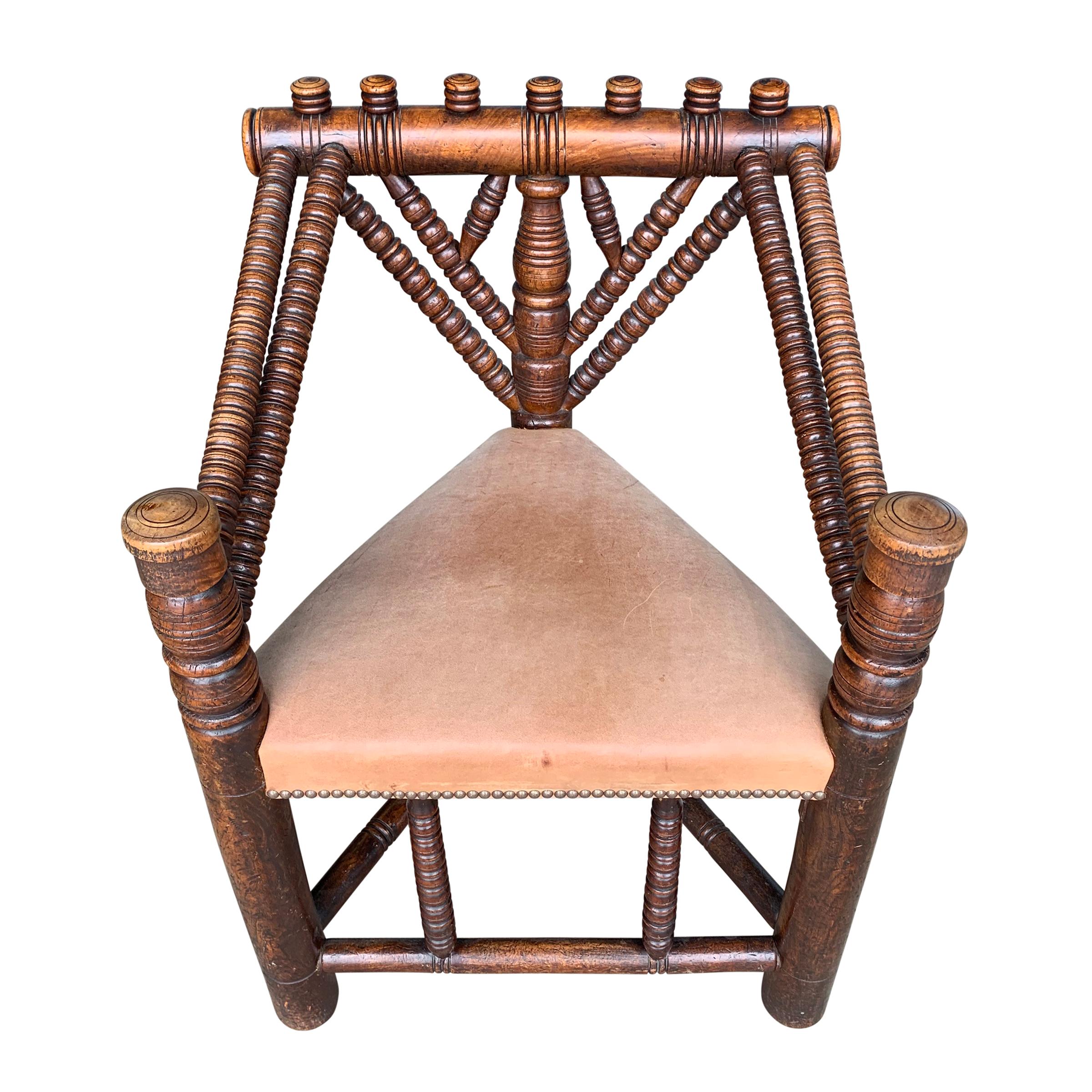 An incredible 18th century English Turner's chair created to show off the talents of a skilled wood turner, with a triangle seat upholstered in a smooth natural leather with nailhead trim, and a wonderful patina.