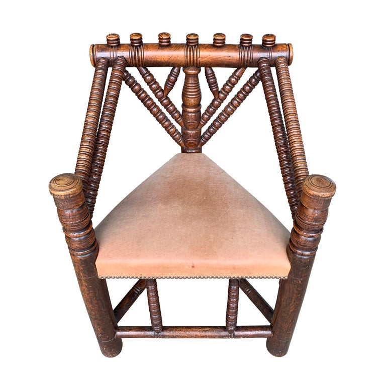 An incredible 18th century English Turner's chair created to show off the talents of a skilled wood turner, with a triangle seat upholstered in a smooth natural leather with nailhead trim, and a wonderful patina. Chairs like these were kept in the