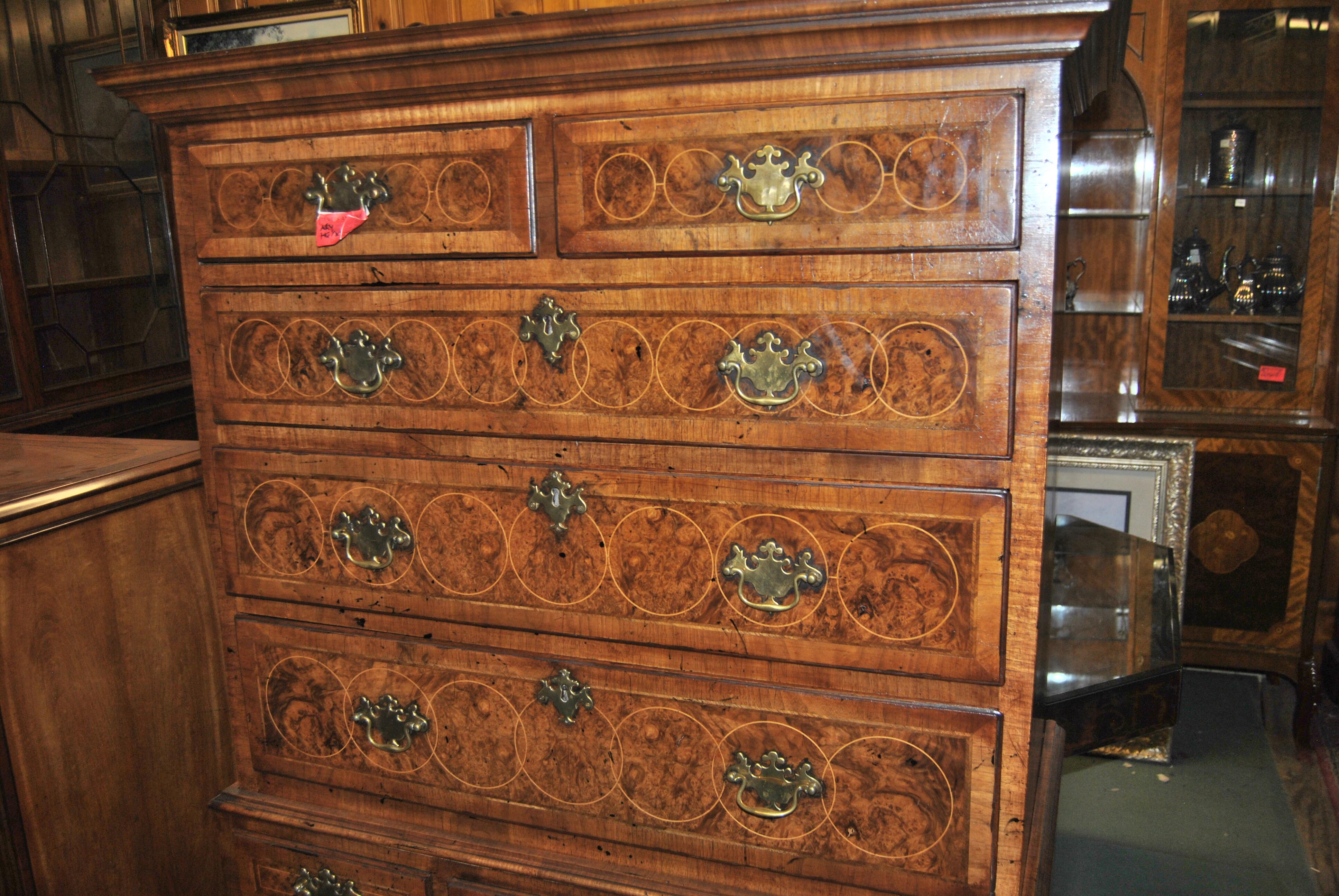 This is a walnut and Kashmir walnut chest on chest made in England, circa 1770. There is a pretty Crown Molding to the top of the Chest. There are 2 short drawers over 3 longer graduated drawers to the upper chest. There are 3 shorter drawers over 2