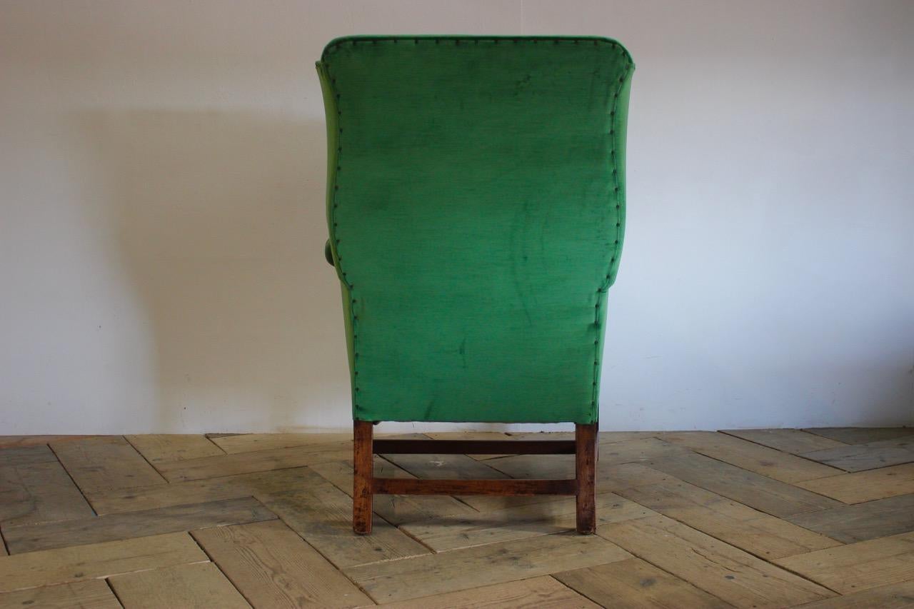 A good quality and very comfortable, 18th century English Country house Wingback armchair, of elegant proportions, having been recently reupholstered by us in a green velvet. Lovely color and proportions 
Additional measurements: Floor to seat :