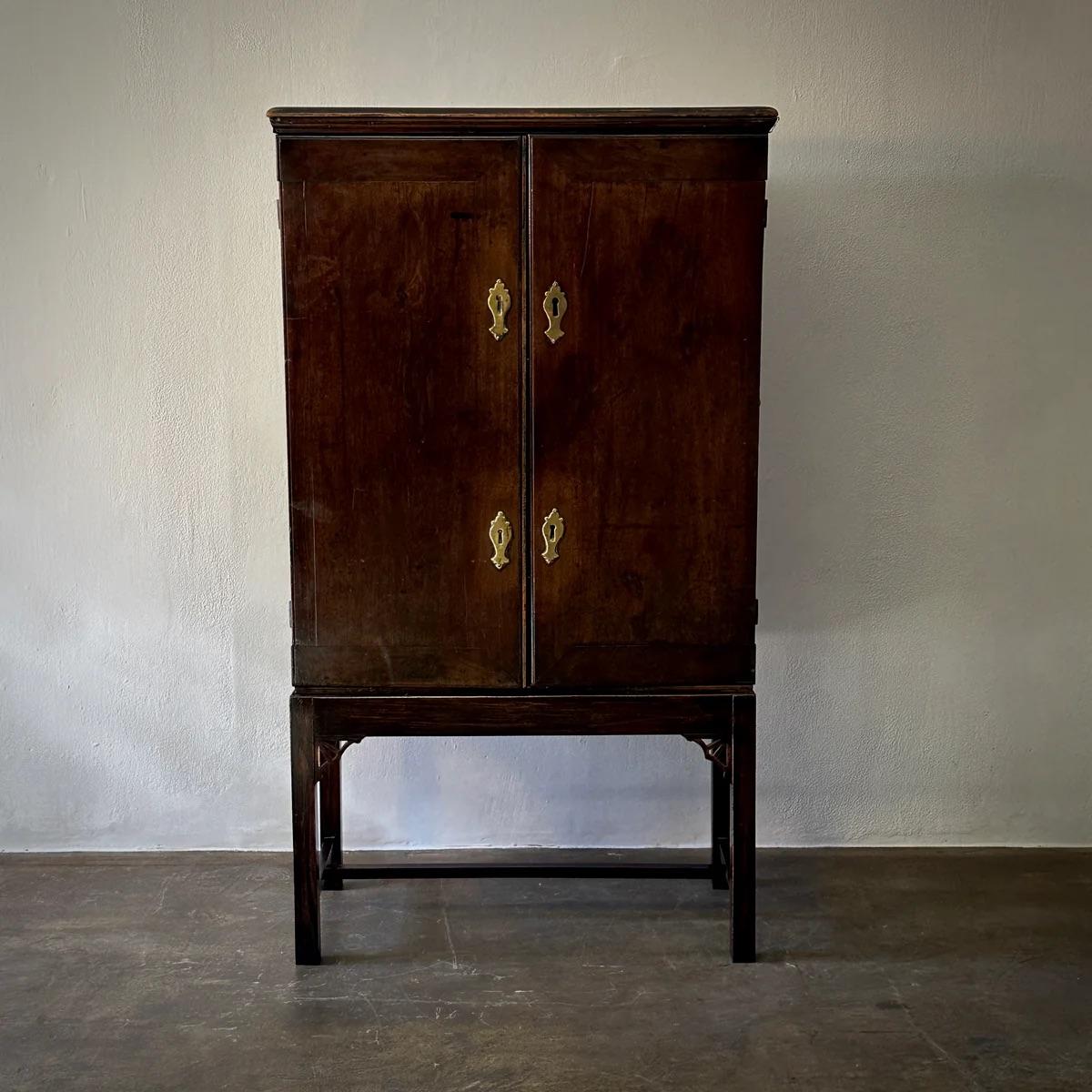 Nachlassschrank aus dem 18. Jahrhundert mit originalen Messingbeschlägen und einer reichen Patina. Der Ständer ist eine spätere Ergänzung, wahrscheinlich aus dem frühen 20. Jahrhundert, und ergänzt das zeitlose Design des Stücks. Der Innenraum mit