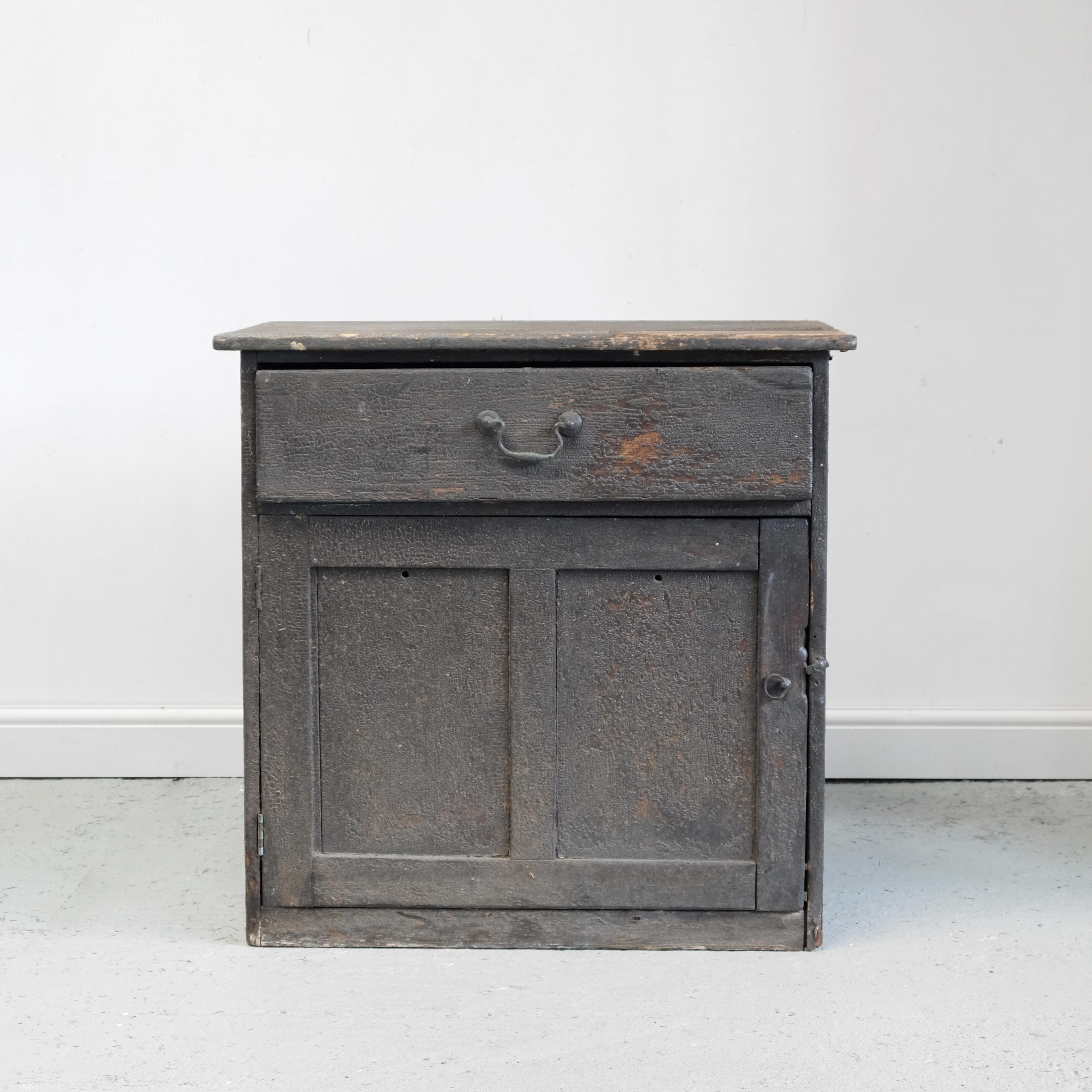 A charming 18th century estate made pine cupboard in completely un-messed with condition. It has a wonderful dry bitumen finish, original swan neck handle and paneled door and sides. The top has an area where there would once have been a carpenter’s