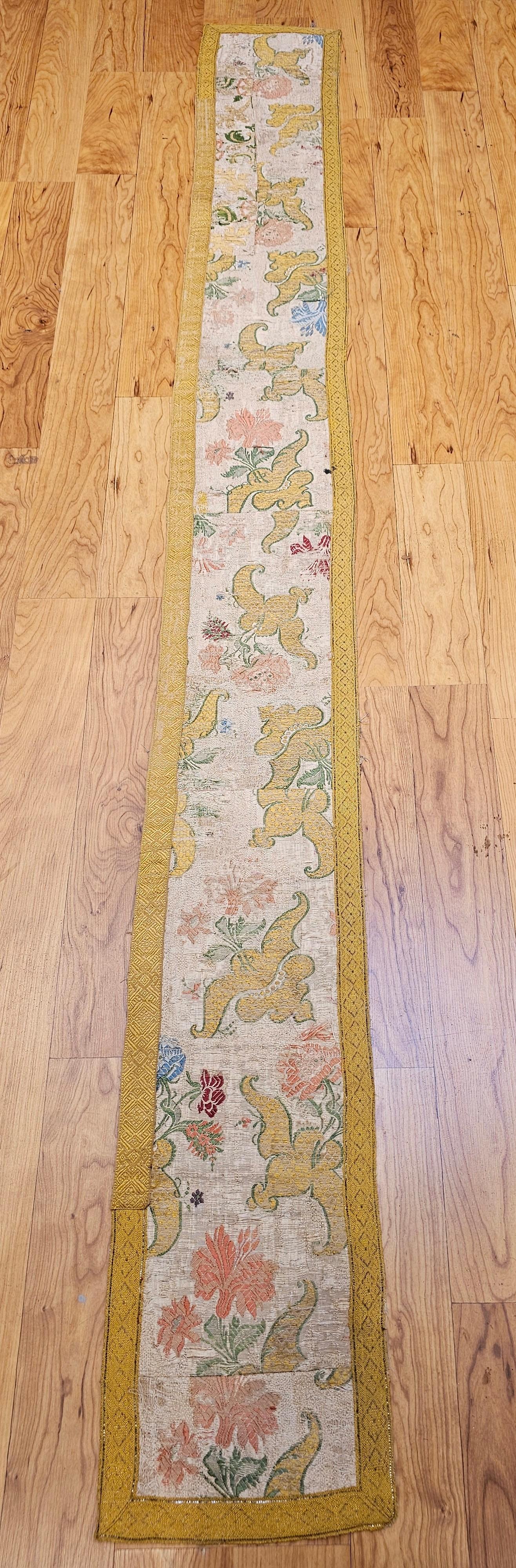 Panneau textile en tapisserie brodée de soie et de fils dorés, réalisé à la main en Europe au 18e siècle. La pièce est réalisée de manière artistique en réutilisant des morceaux de robe brodée à la main ou de châle de vêtement pour en faire un
