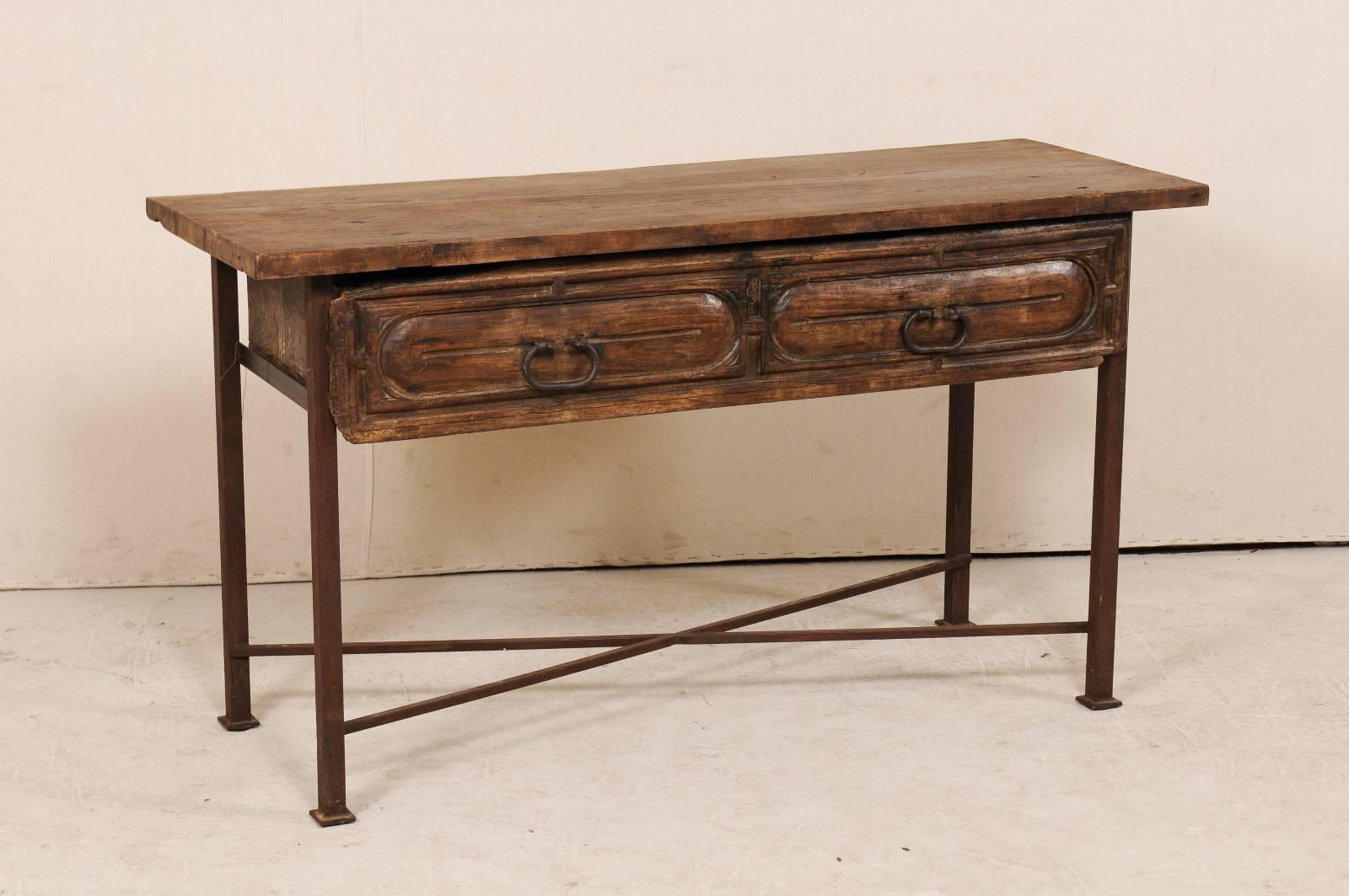 A custom table fashioned from an 18th century Spanish drawer. This unique table features an exquisite 18th century Spanish wood carved drawer with it's original forged iron hardware. The drawer has been set into a custom patinated iron base and an