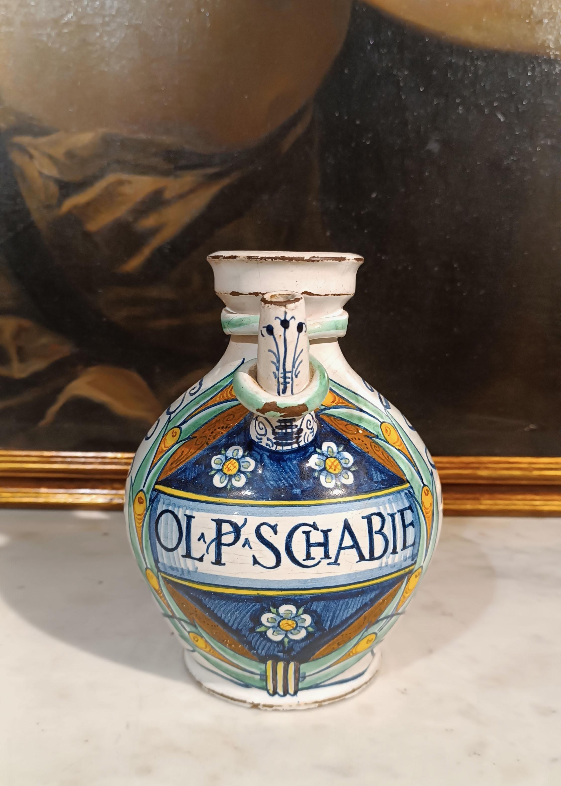 This polychrome glazed majolica pharmacy jug represents a precious example of 18th century Faenza craftsmanship. Its combination of bright colors and its richly detailed decoration make this jug one of a kind. The use of cobalt blue, green and