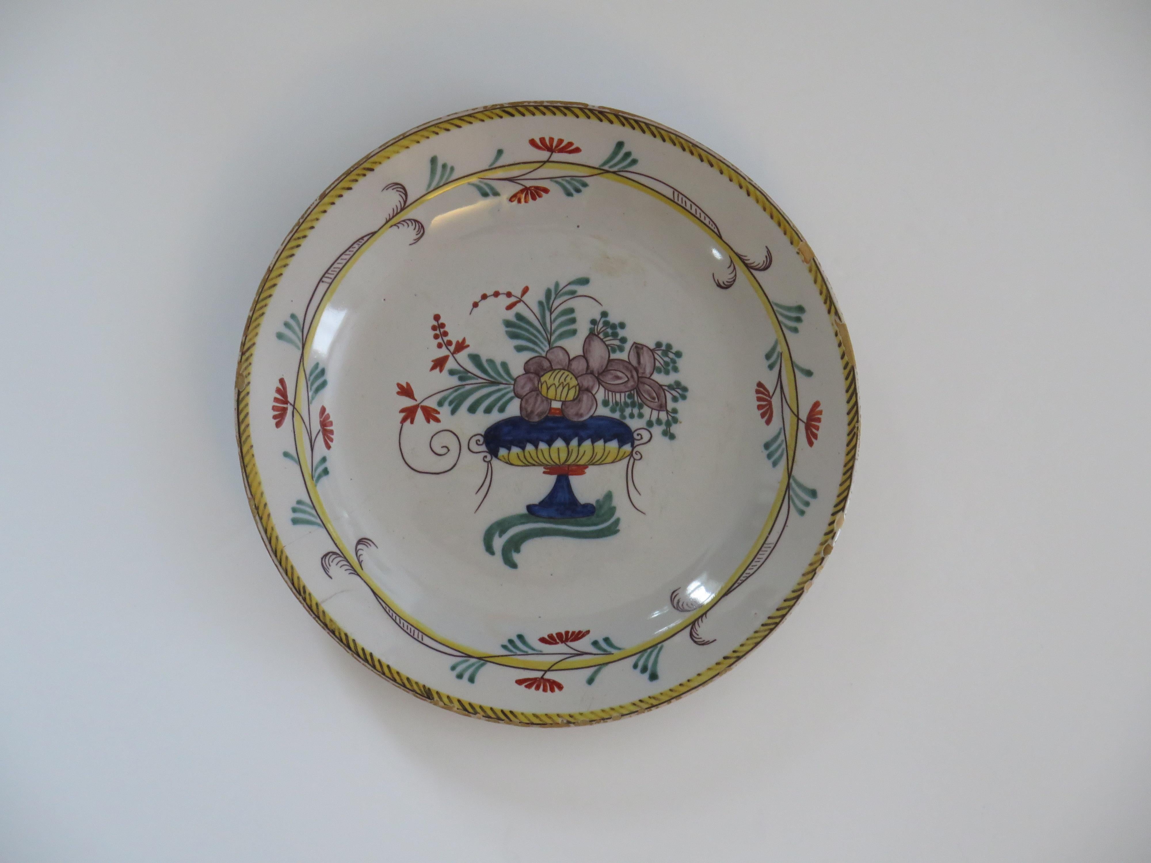 This is a very decorative French Faience plate dinner plate made from tin-glazed earthenware (pottery) which we date to the late 18th century.

The plate has a pan shaped base with no foot rim.

This plate is hand-painted in a flowing style with