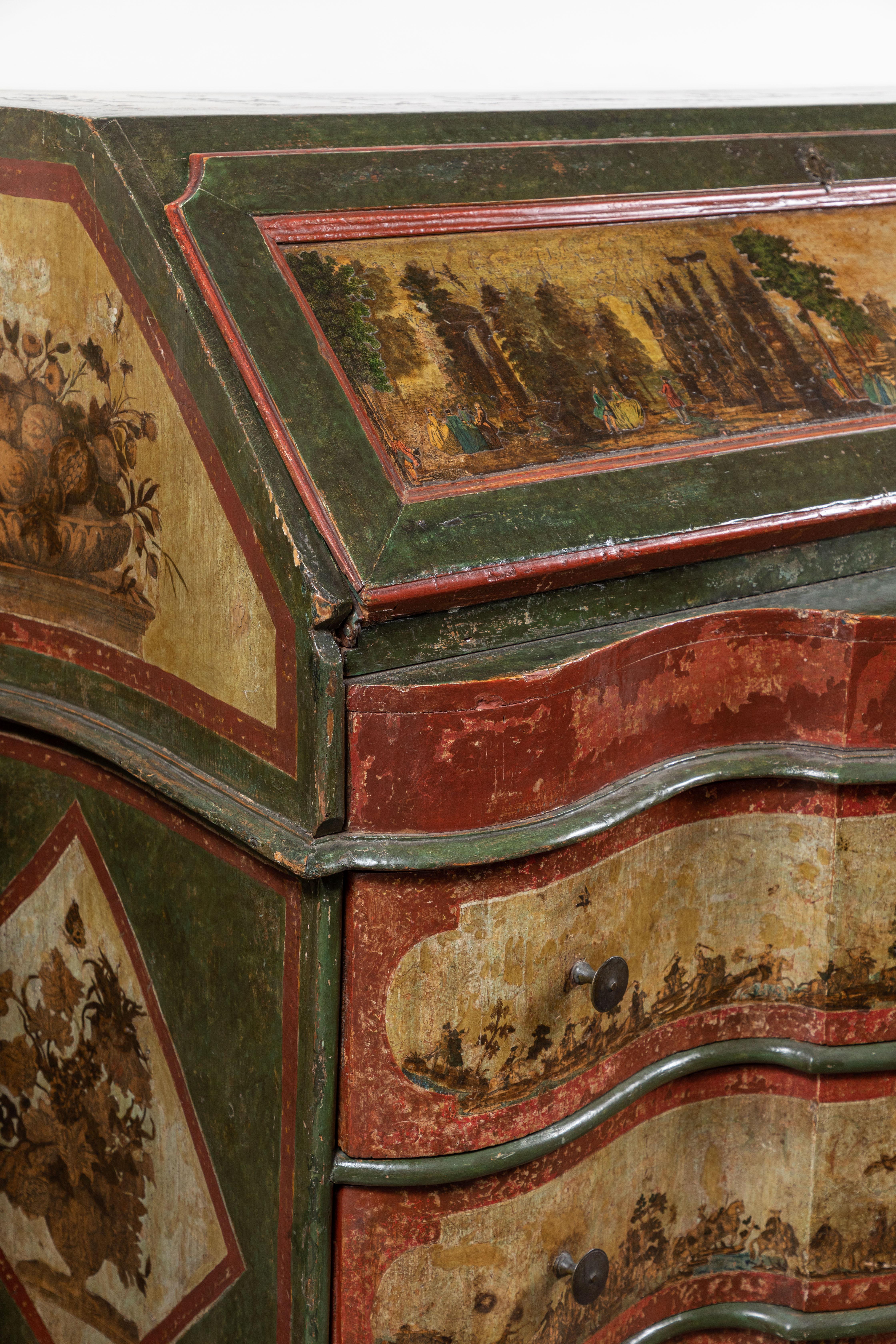 Reich kolorierter, um 1790 entstandener Schreibtisch aus Sizilien mit drei Schubladen, Serpentine und Sturzfront. Das Ganze ist mit Decoupage bedeckt, die Tafeln mit Früchten, Blumenzweigen, Insekten, marschierenden Soldaten und Capriccio-Szenen von