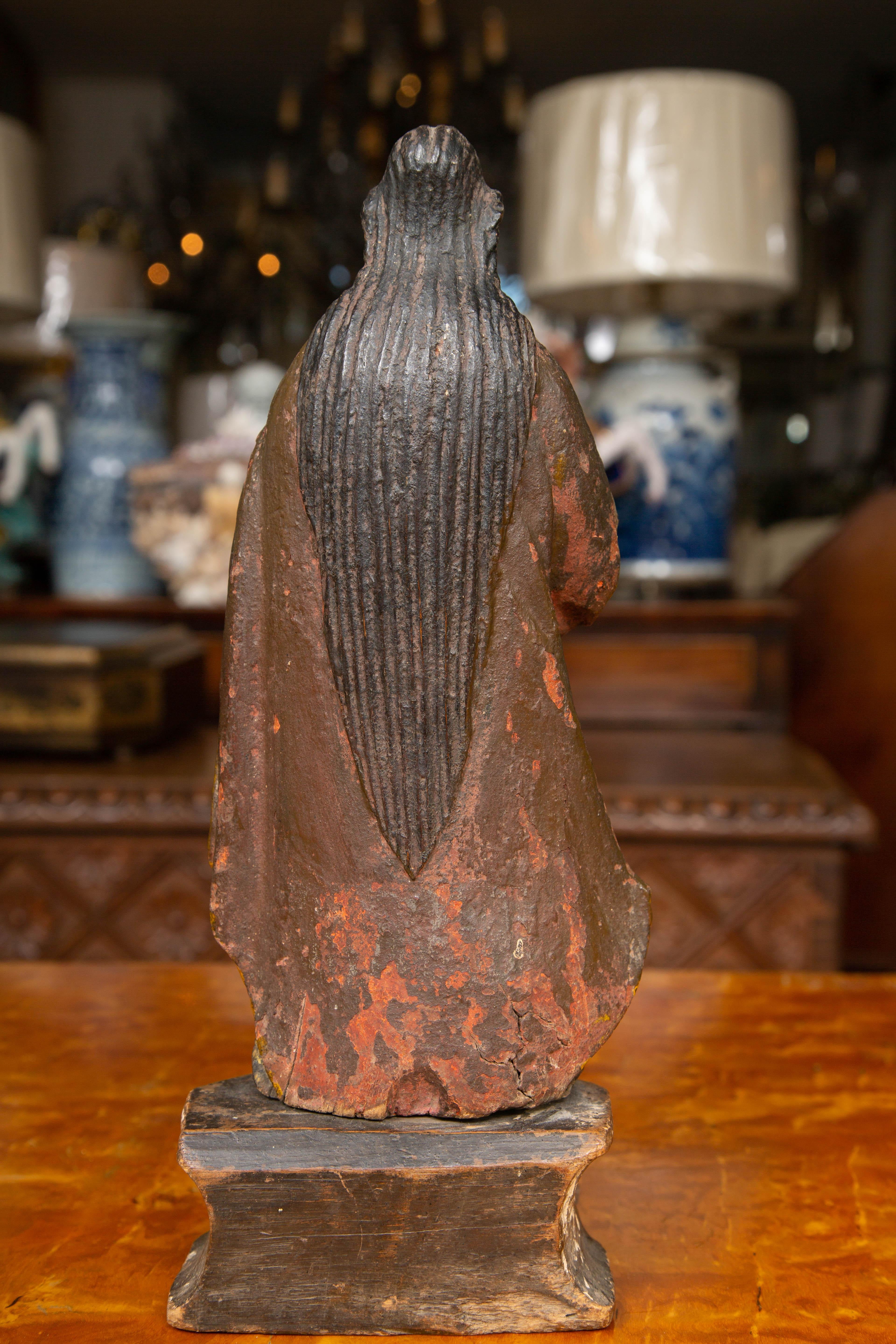 Se trata de una figura religiosa tallada a mano y policromada. La santa está vestida con una túnica vaporosa, de pie sobre un pedestal. El acabado policromado es una mezcla de azules, amarillos, blancos y rojos apagados. El acabado naturalmente