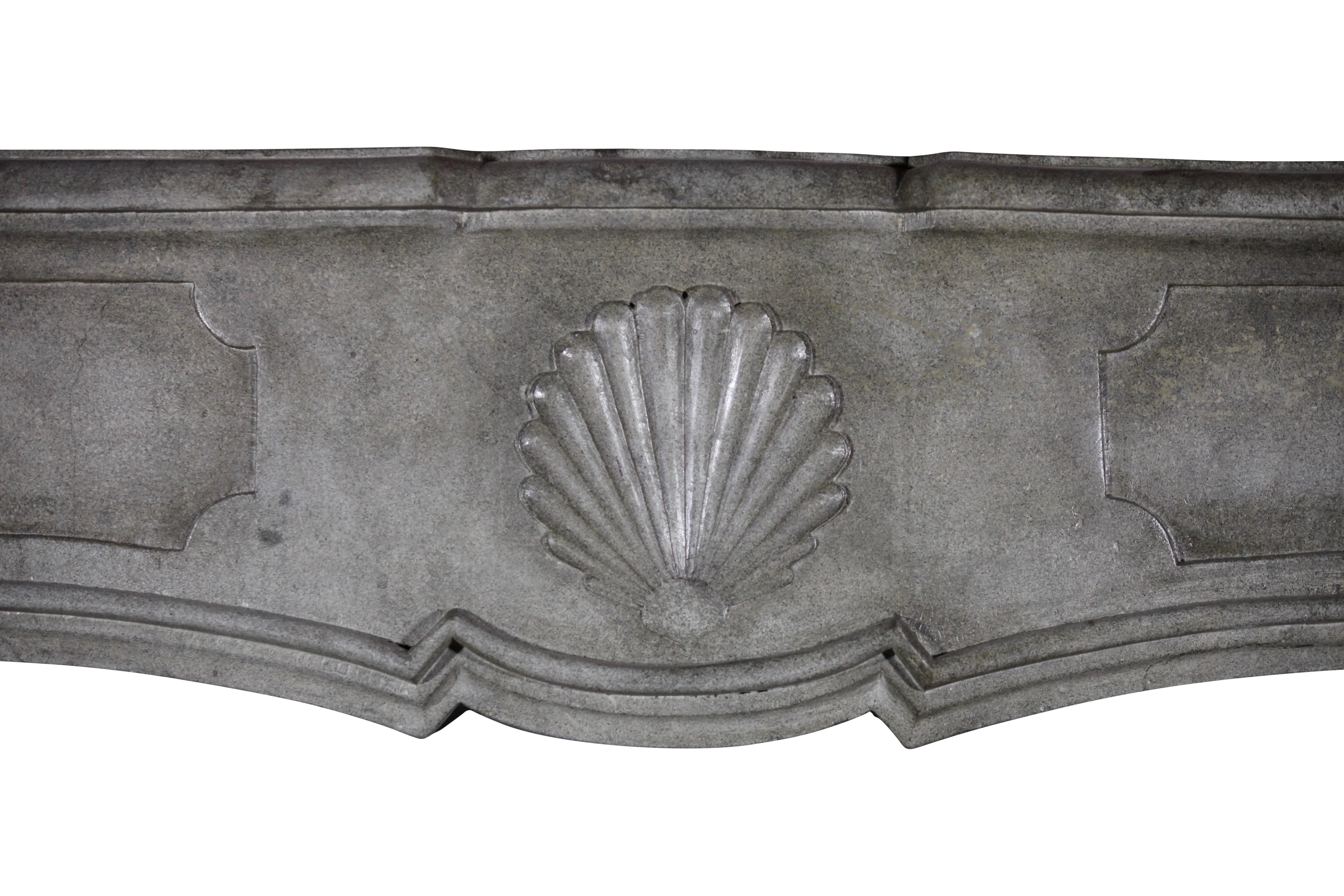 This is a grand, one of a kind, original French antique fireplace surround. It was made in a grey bicolor Marble hard stone. It reflects the light in the room and has a silky feeling touching it. The depth the pannels on the front are rich. The