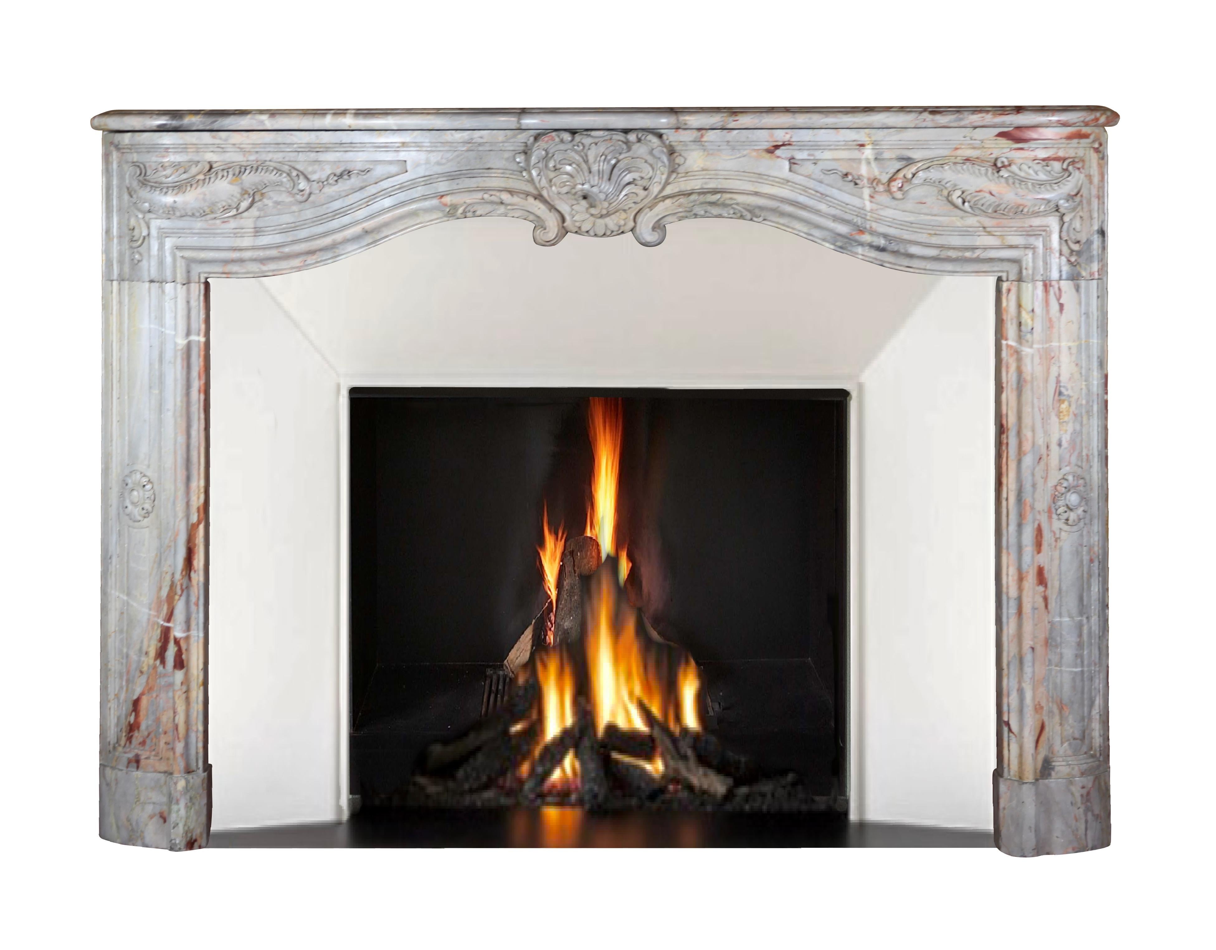 This is a extra fine sculpted chimney piece of the French regency period, 1st half of the 18th century. The Royal Saracolin marble was used in many luxury decors of that time period. It was reclaimed from a grand Antwerp Notary
