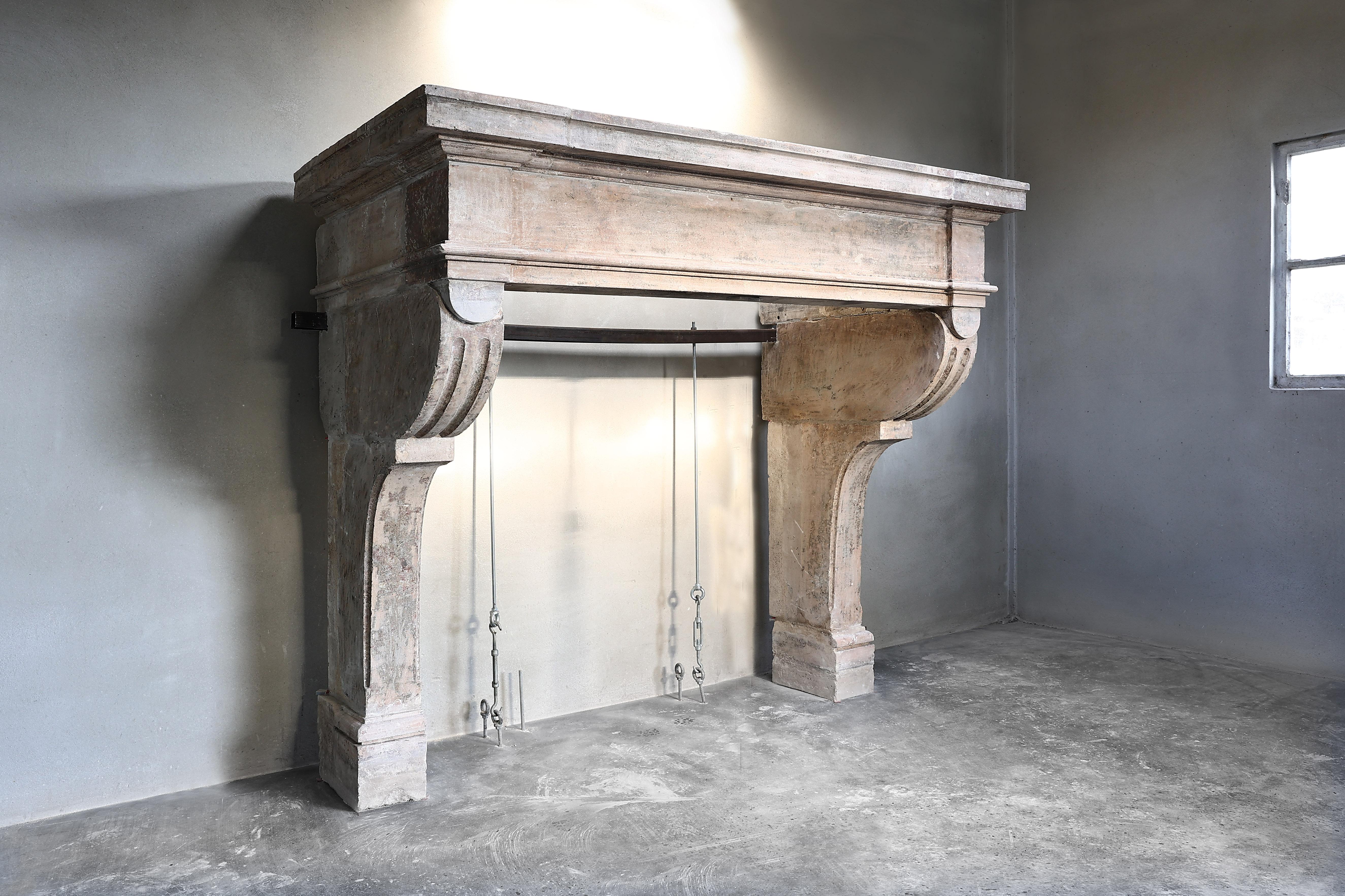 Very special and unique castle fireplace of French limestone. An antique fireplace from the 18th century in the style of Louis XIII. A robust and elegant fireplace due to the beautiful ornaments and lines. The legs are fitted with flutes and the
