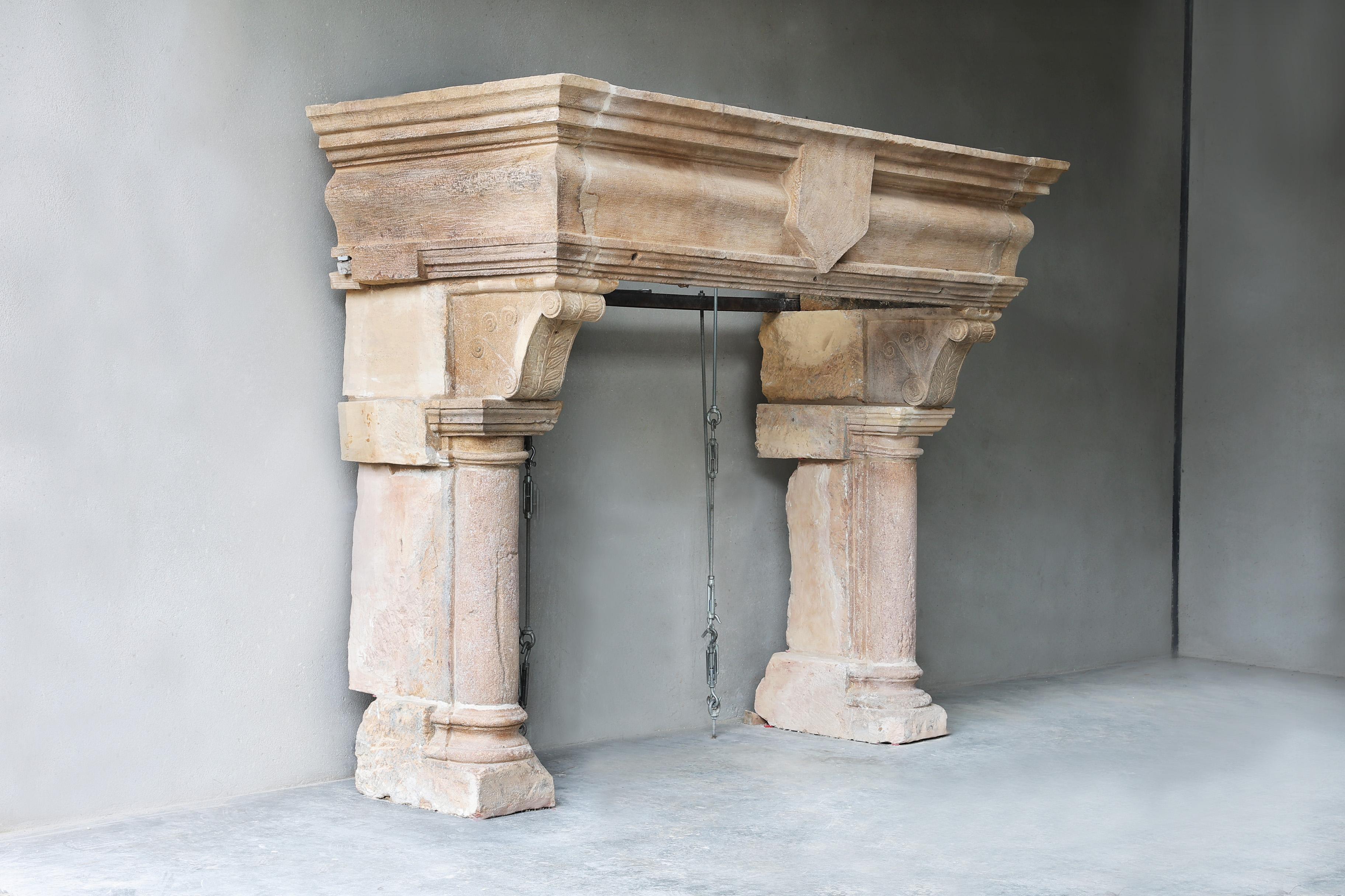 Beautiful imposing castle fireplace from the 18th century of French limestone in style of Louis XIII. This antique fireplace comes from a famous restaurant in France and has a special ornament in the middle of the front part. The various decorations