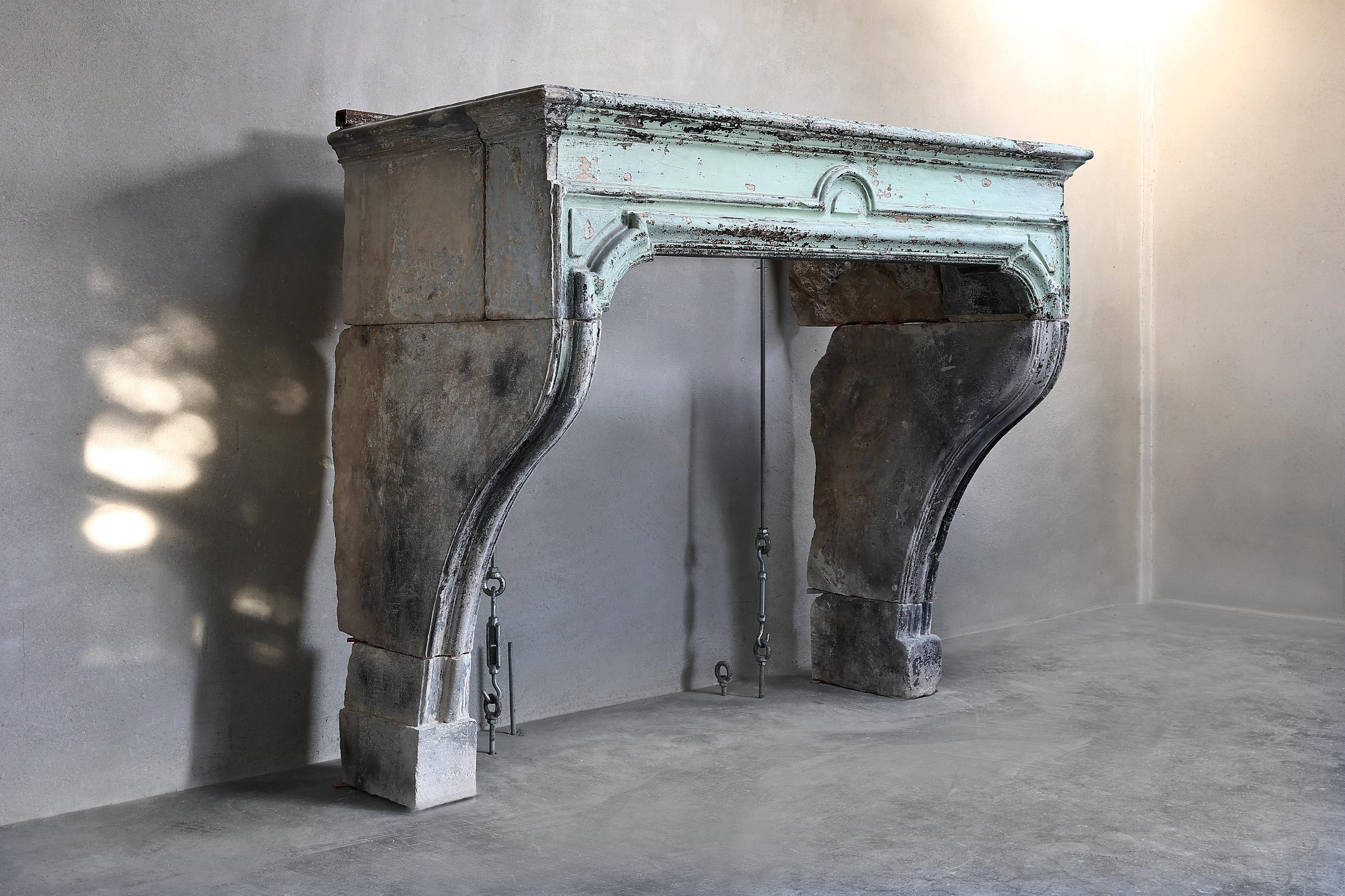 Antique patinated fireplace of French limestone from the 18th century! Beautiful fireplace in the style of Louis XIV. This mantle has a beautiful ornament in the middle of the front part and beautiful lines that show the shape of the fireplace.