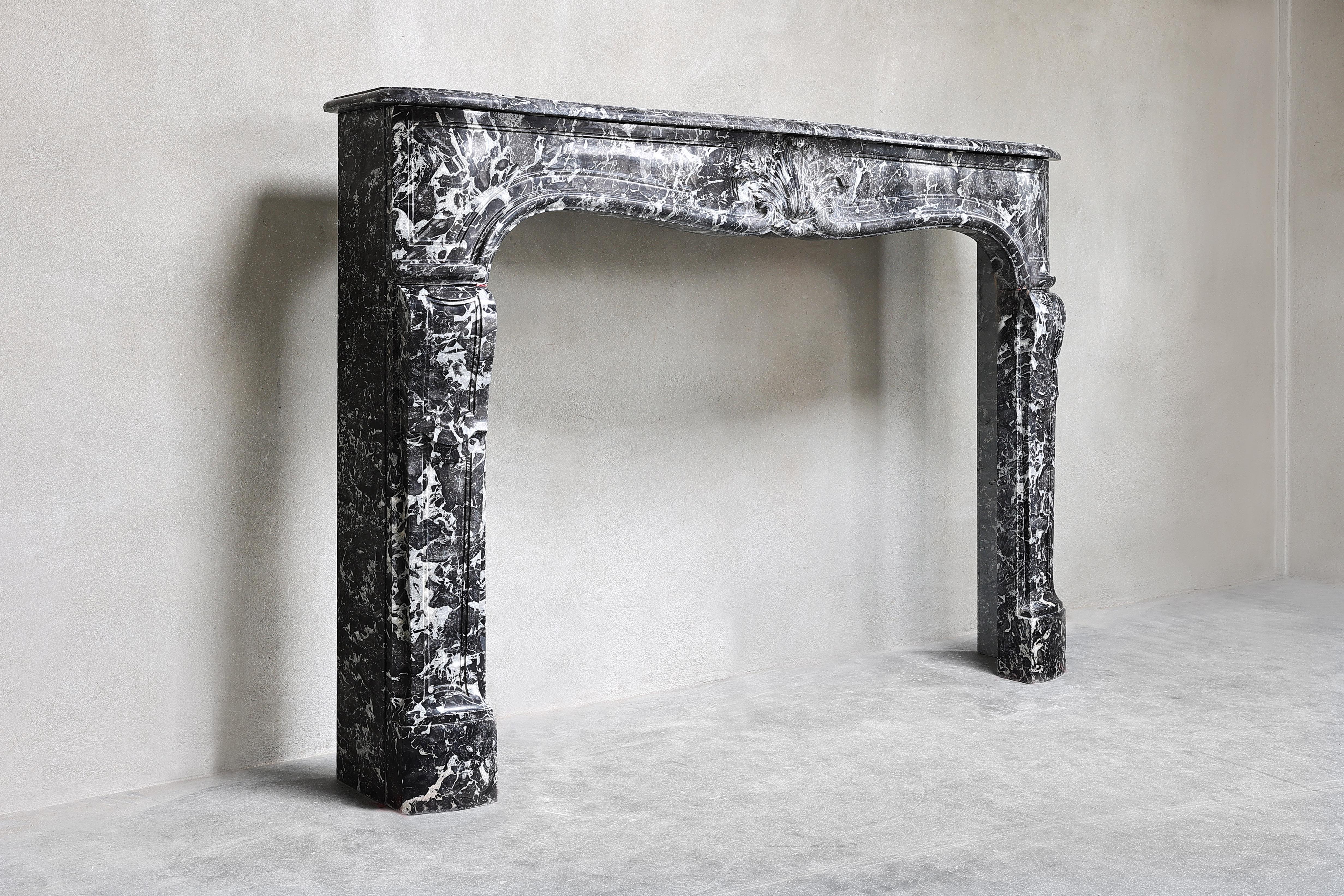 18th century antique fireplace of Saint Anna marble from Belgium! A beautiful grey/black marble with light veins! A fireplace with round shapes and a scallop in the middle of the front part. This fireplace is in the style of Louis XV and has