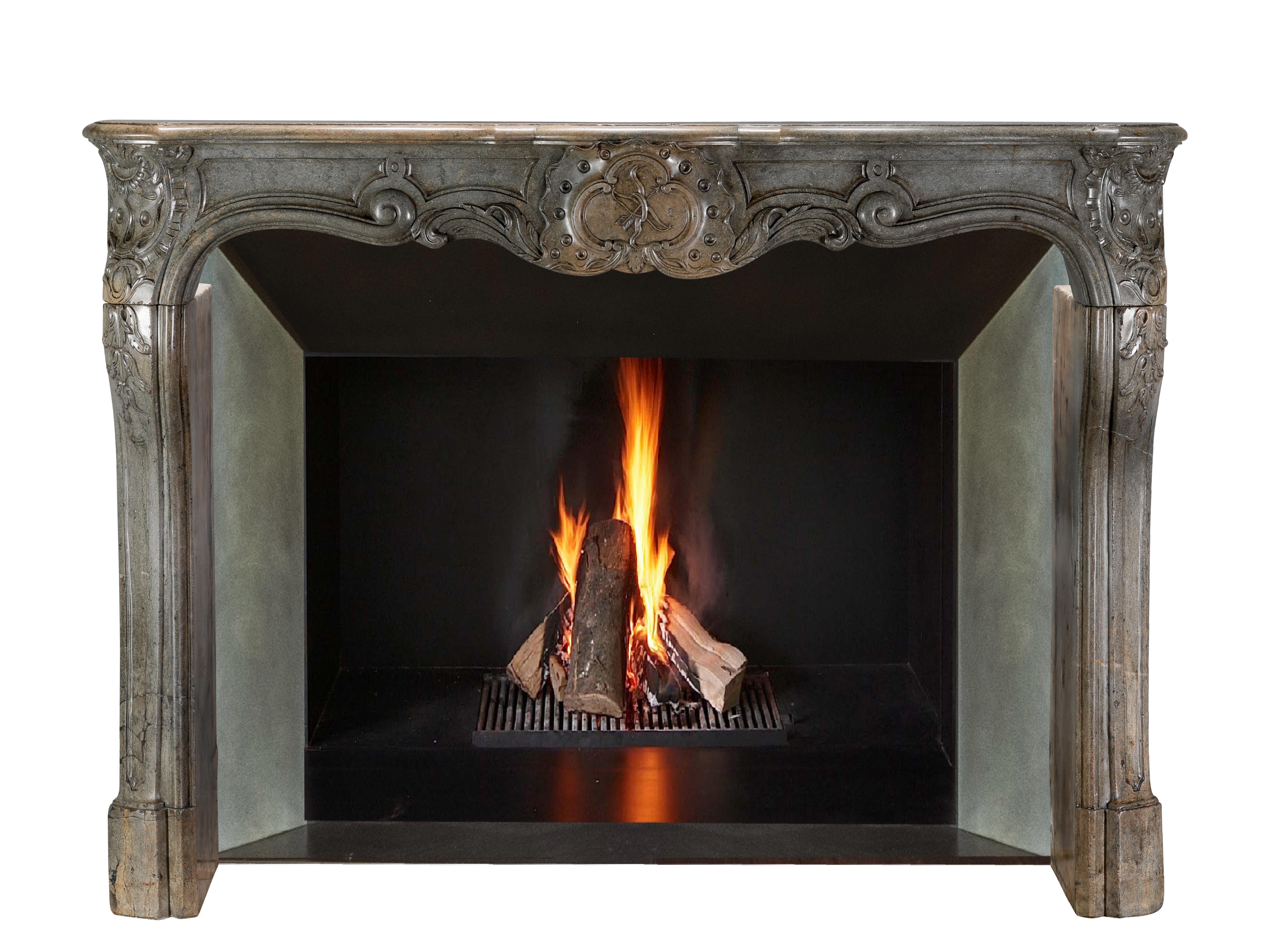 Very unusual hard stone chimney piece. Fronton in arbalette. This fireplace surround is definitely a statement objet for the connoisseur. Amor central motif, made on special request. Regency Period, 18th century. Few pieces can beat this kind of