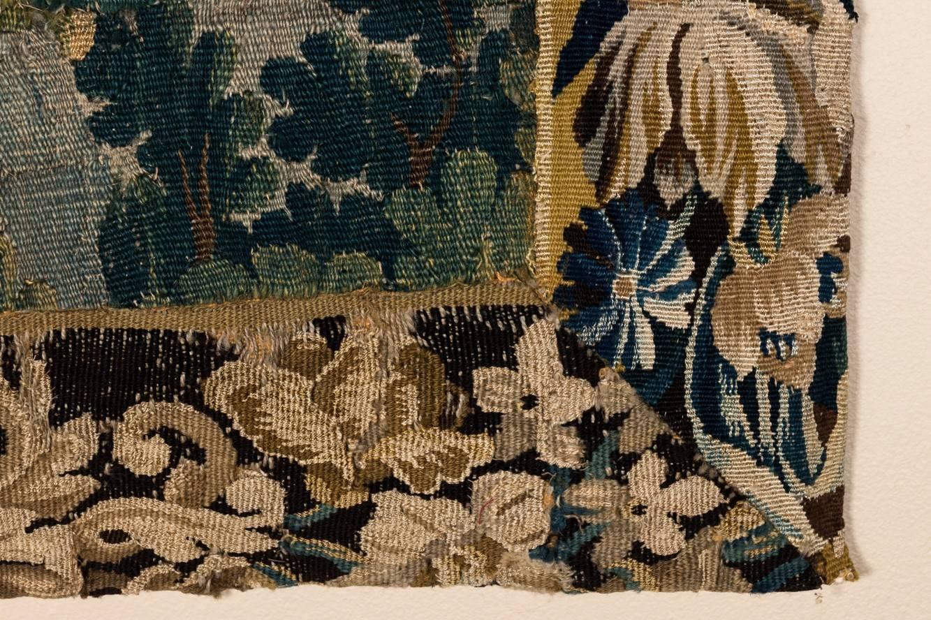 Handwoven Flemish tapestry with a landscape scene featuring a castle, circa early 18th century.
 